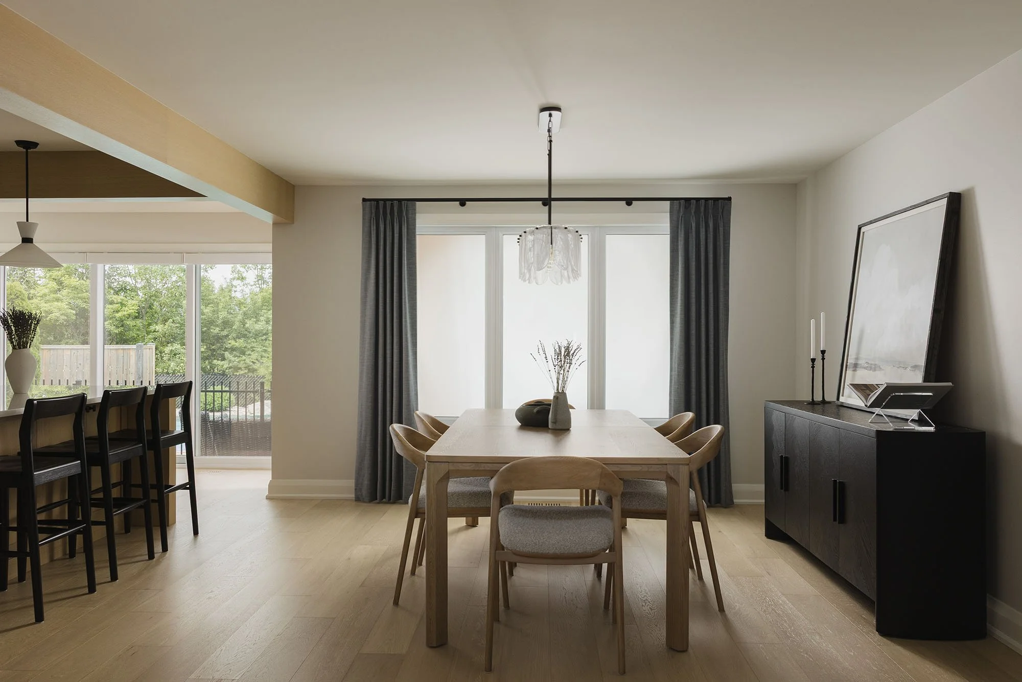 Kitchen renovation in Ottawa featuring an open concept dining room with custom drapery and a white oak table and chairs. 