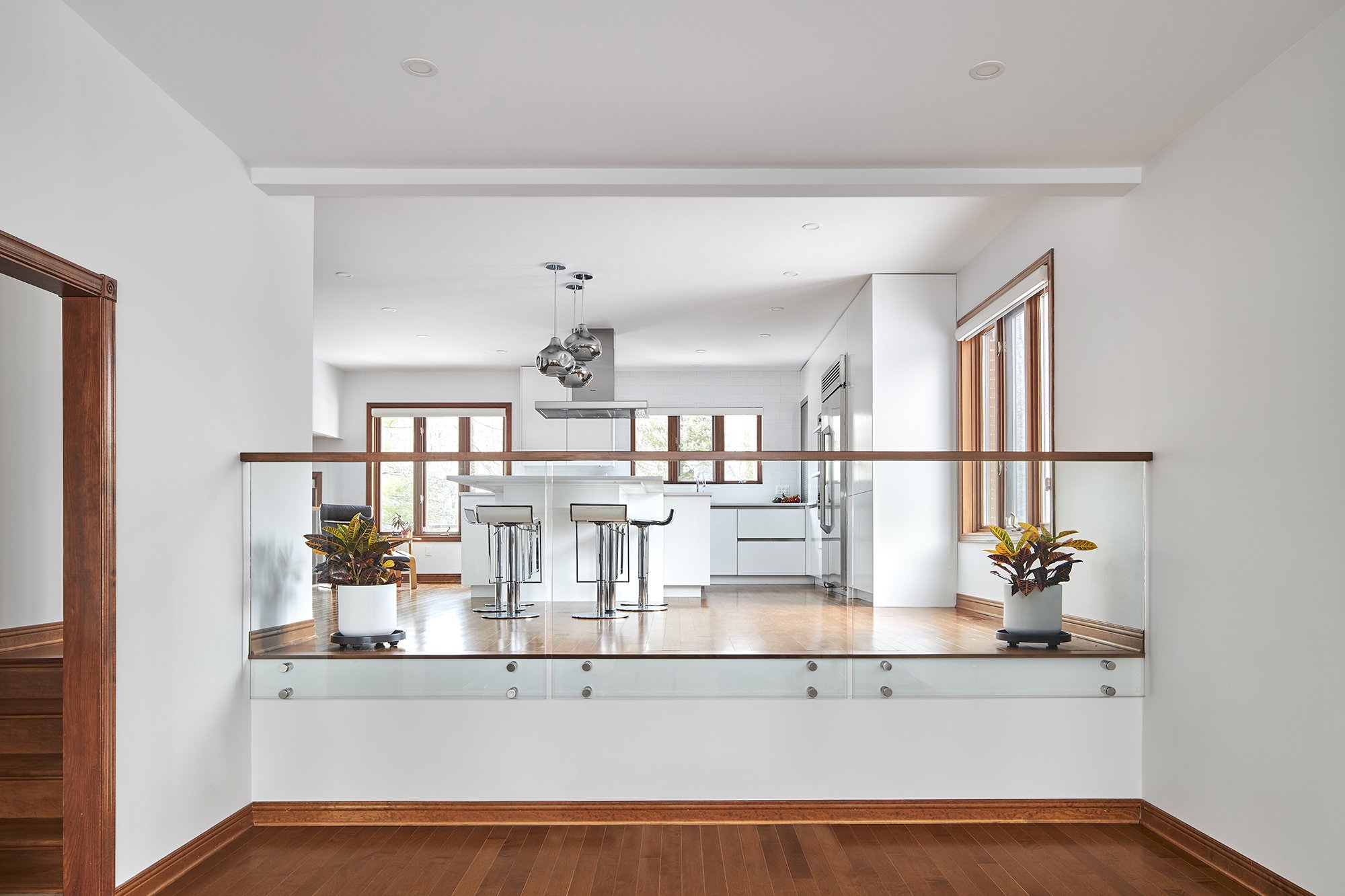 Modern custom kitchen renovation in Ottawa featuring flat panel cabinets and a glass railing. 