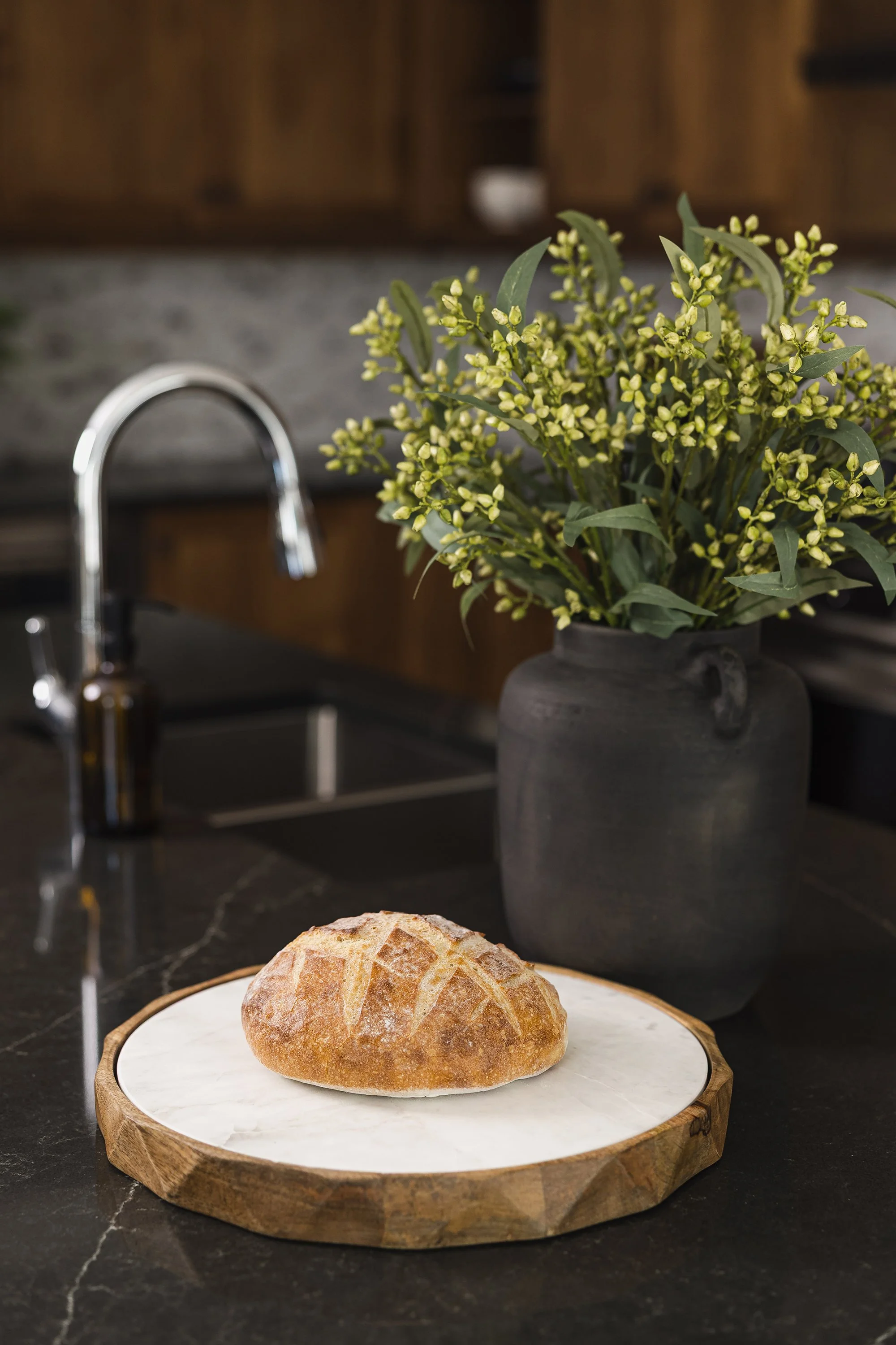 Custom kitchen renovation in Ottawa featuring warm maple cabinets and a polished black quartz countertop. 