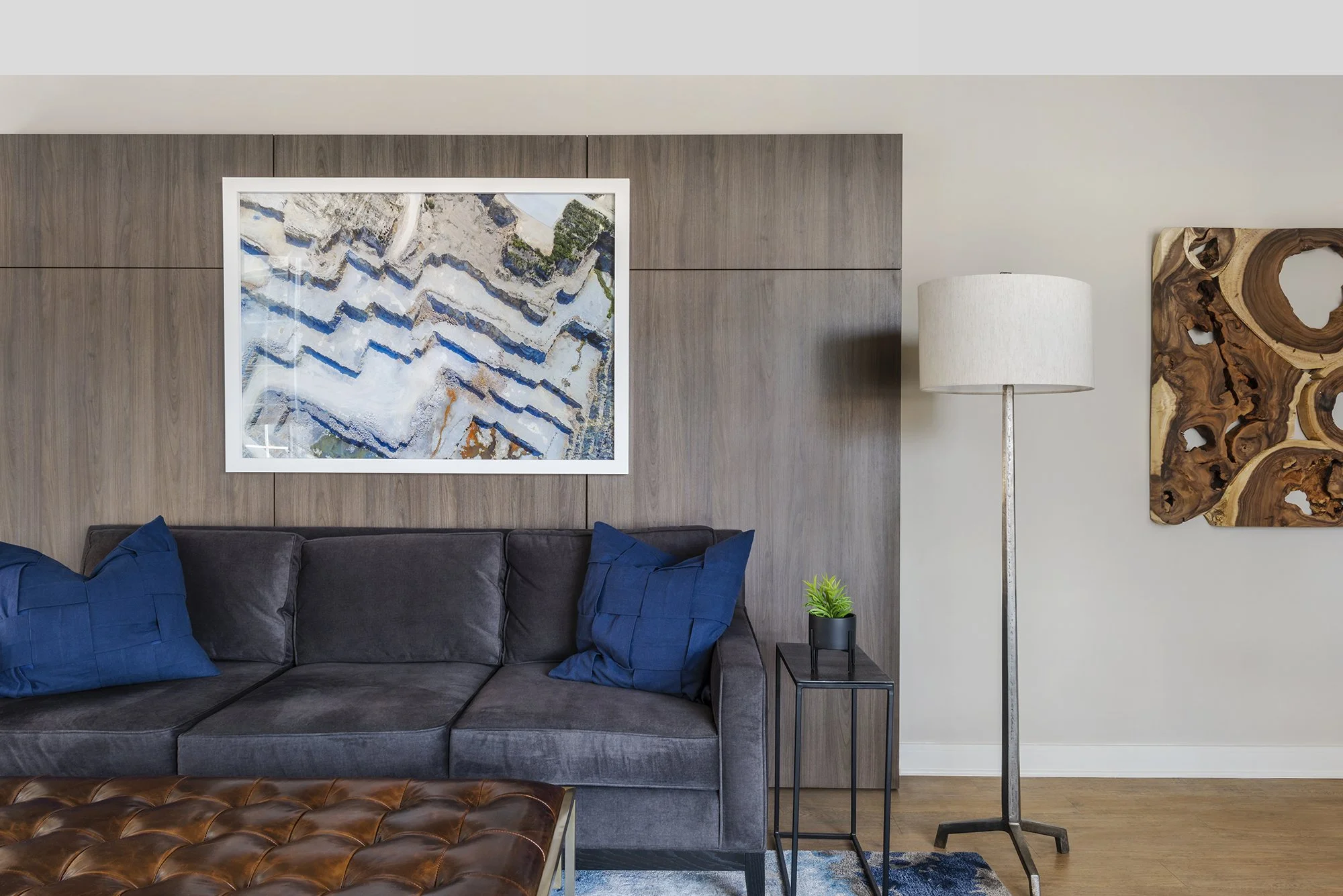 Family room makeover in Ottawa featuring a walnut wood accent wall and a charcoal velvet custom sofa. 