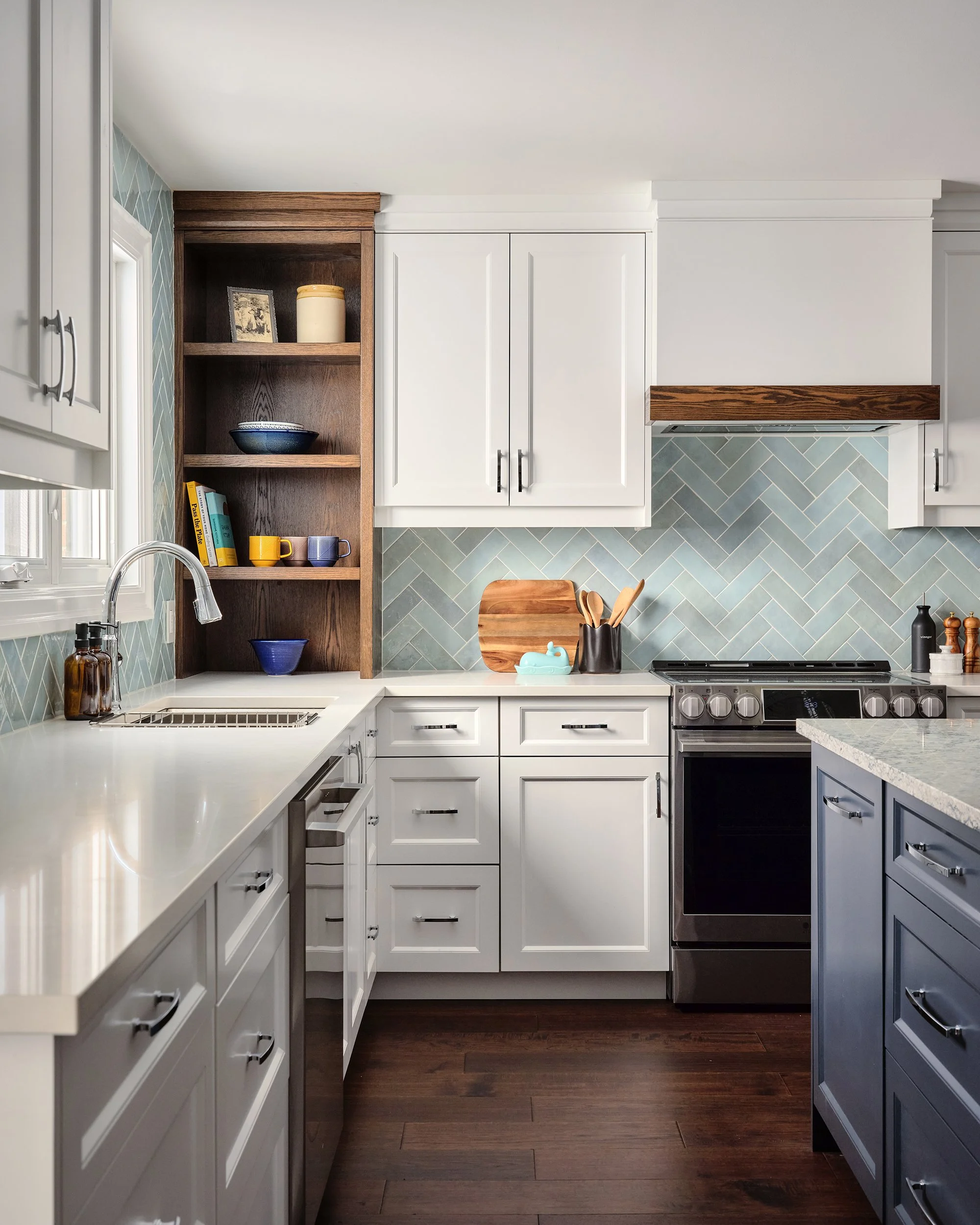 Custom kitchen design for an Ottawa family home featuring white and navy shaker cabinets and warm oak accents.