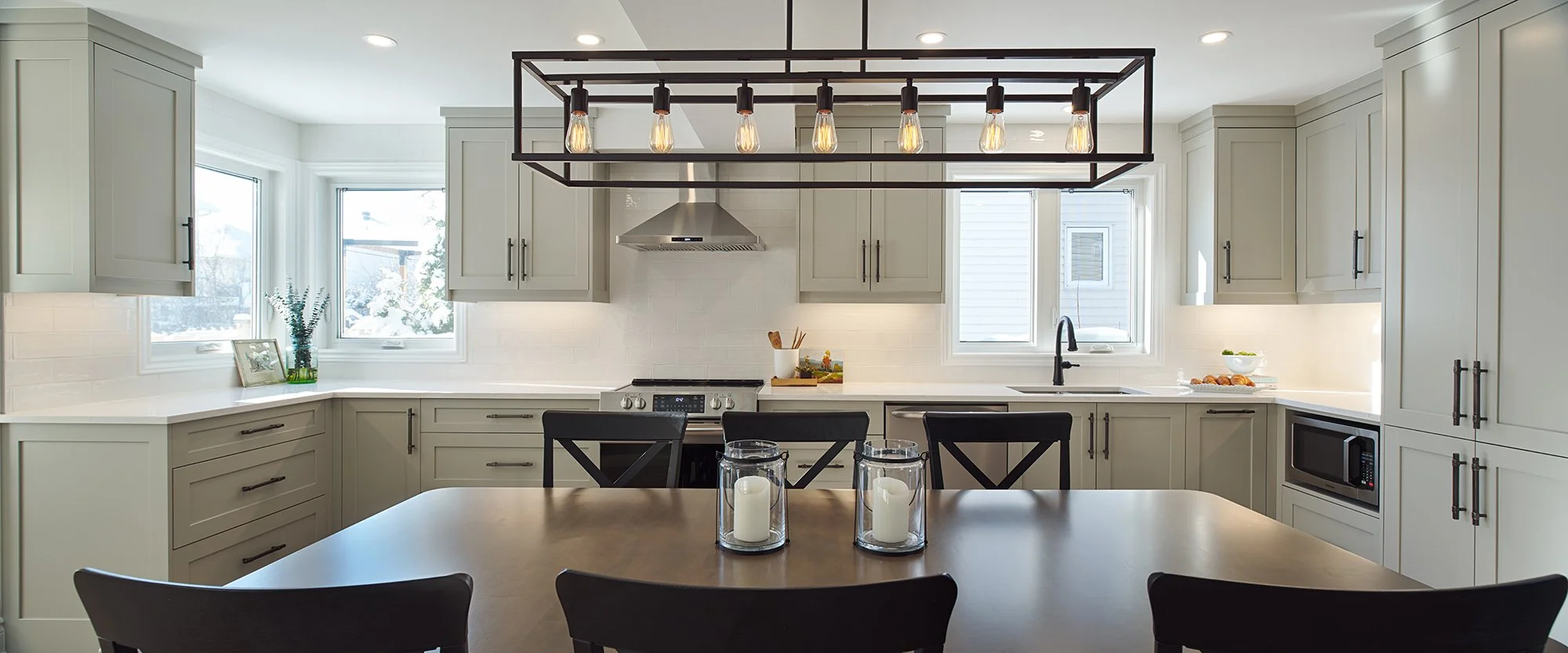 Custom open concept kitchen renovation in Ottawa featuring warm grey shaker cabinets and industrial accents. 