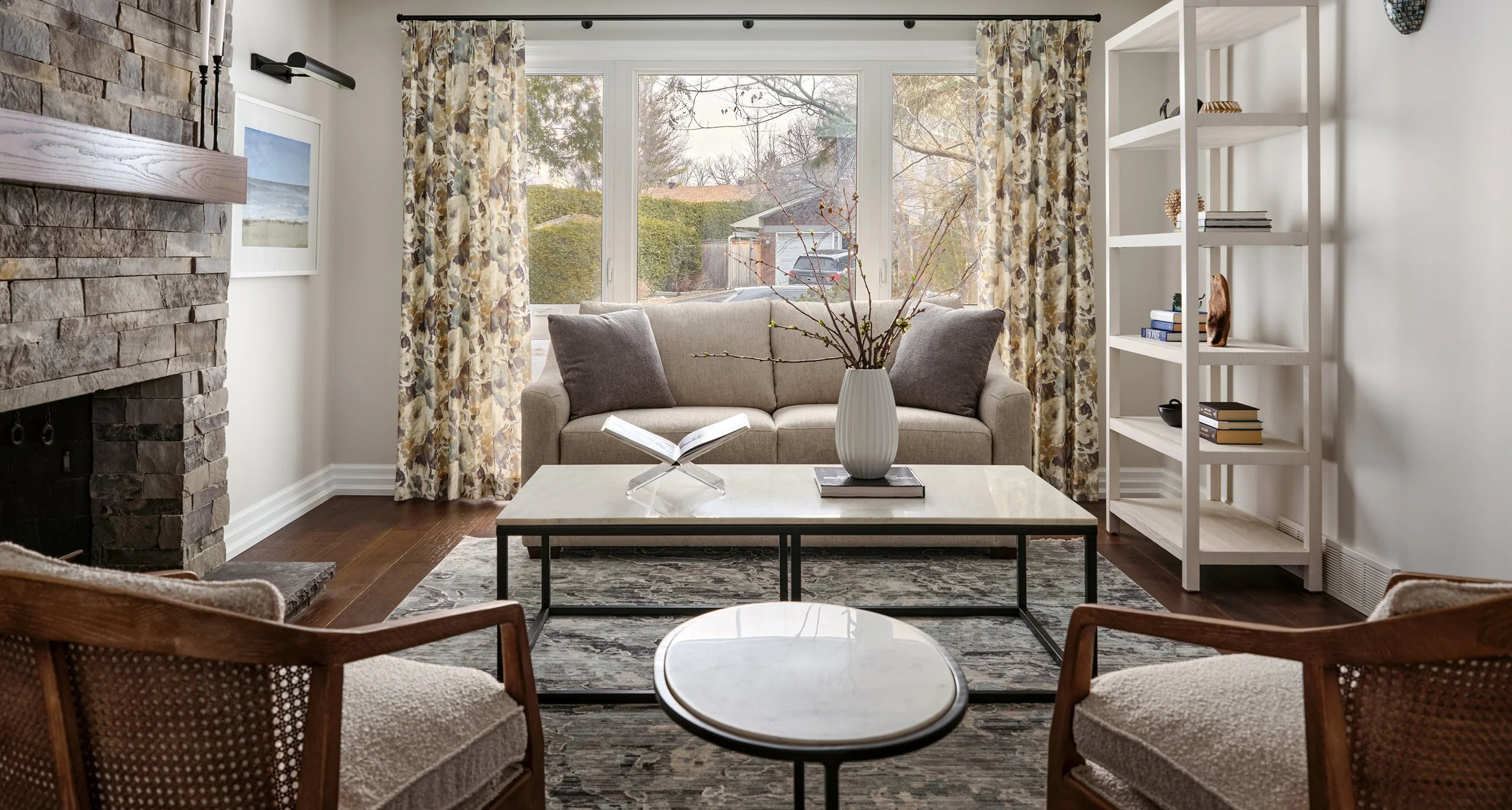 Living room design for an Ottawa family home featuring floral drapery and a stone fireplace