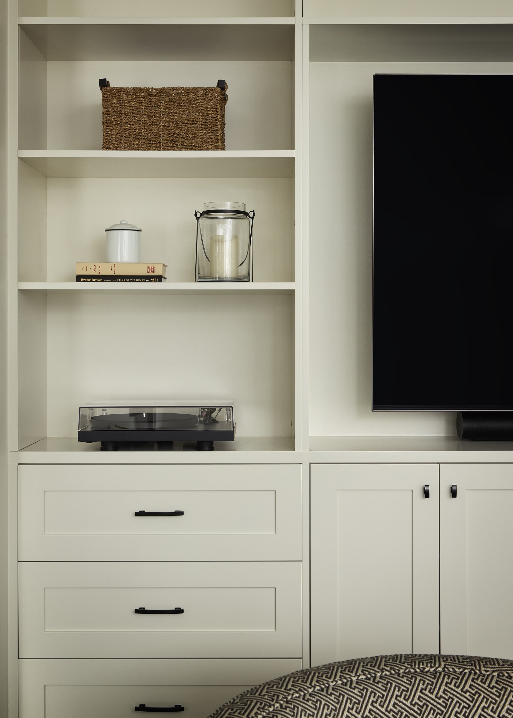 Family room renovation in Ottawa featuring a creamy white custom entertainment unit with a dedicate spot for their record player and records. 