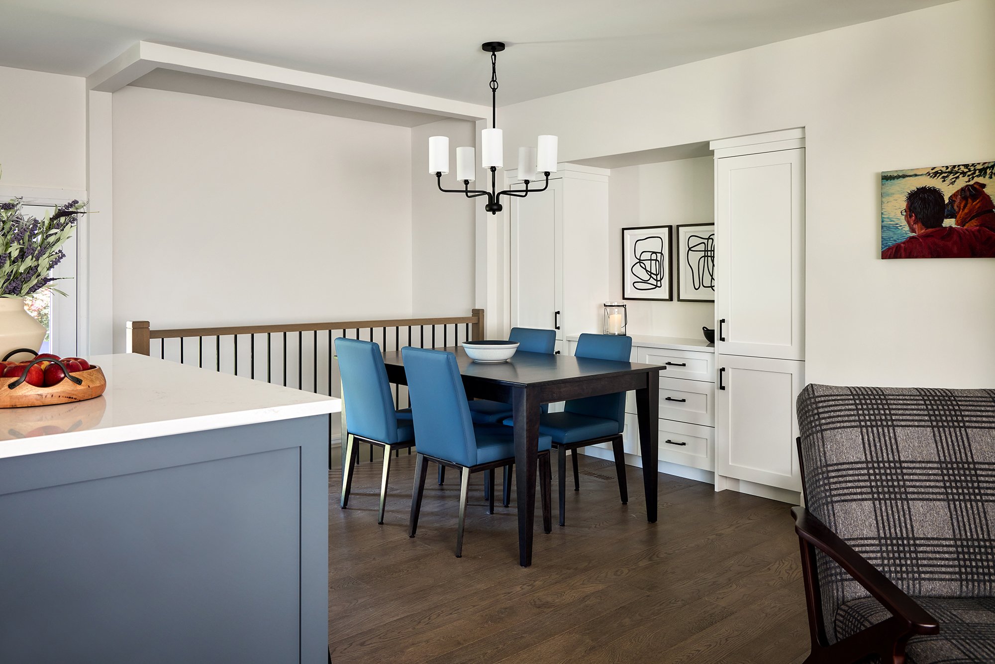 Open concept home design for an Ottawa family home featuring an extendable table and 4 upholstered blue dining chairs. 