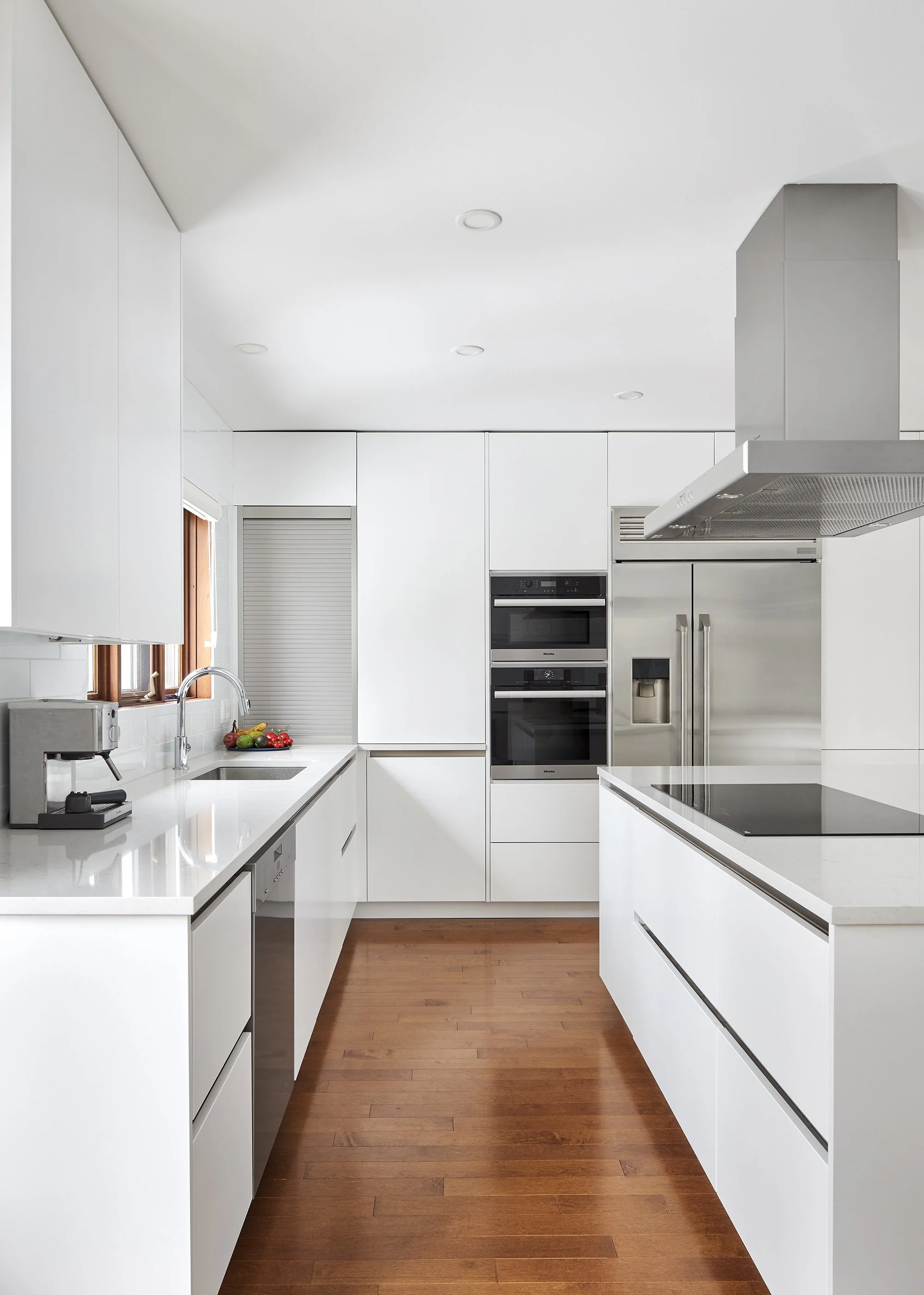 Modern custom kitchen renovation in Ottawa featuring flat panel cabinets and a warm hardwood floors. 