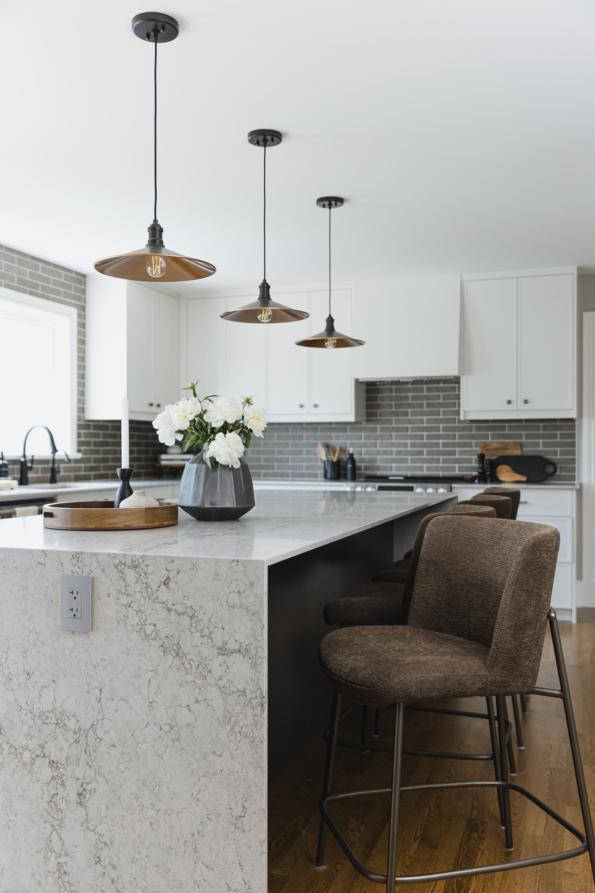 Custom kitchen design for an Ottawa family home featuring a waterfall counter with plugs. 
