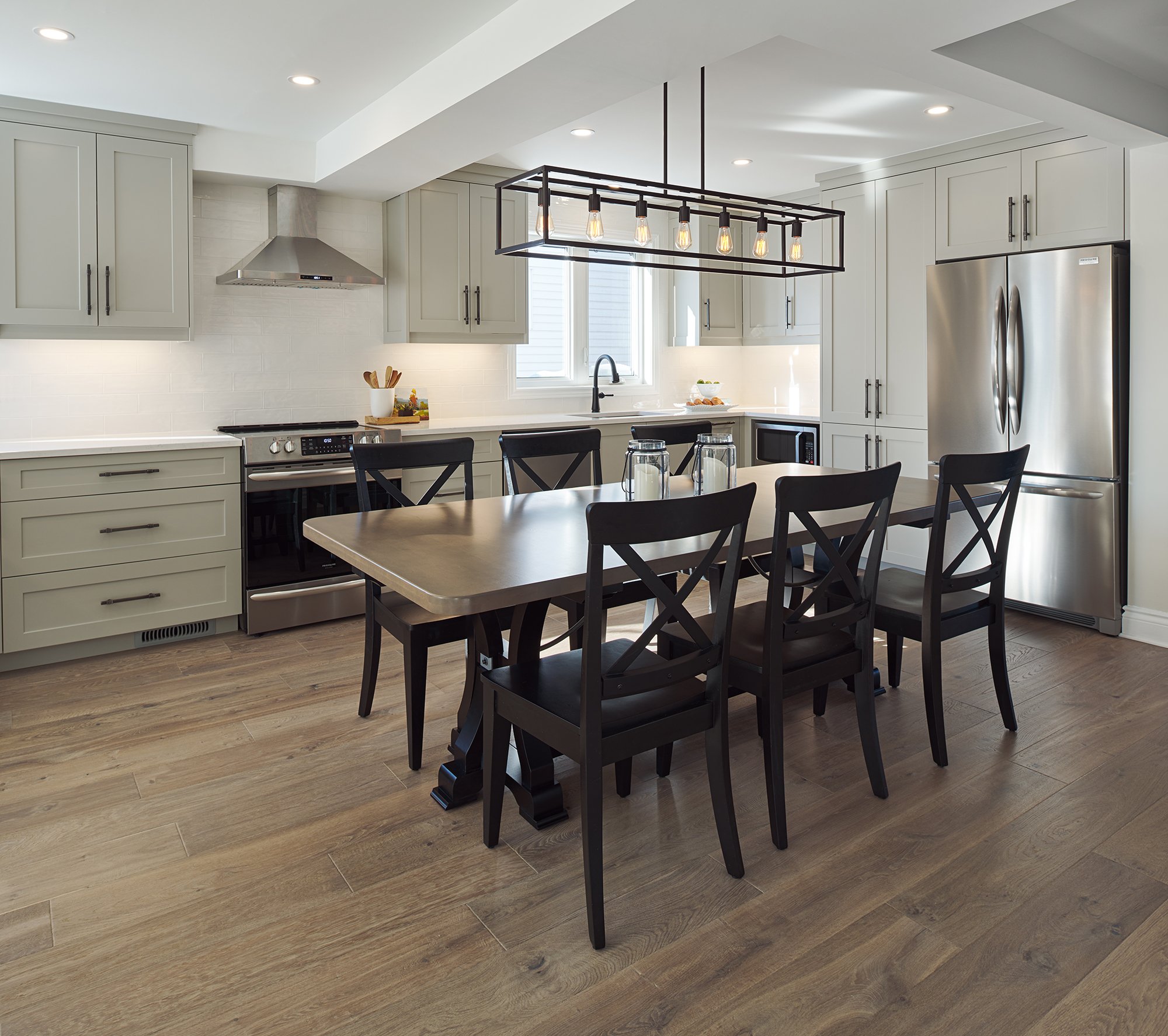 Custom kitchen renovation in Ottawa featuring warm grey shaker cabinets and a farmhouse table for large family gatherings. 