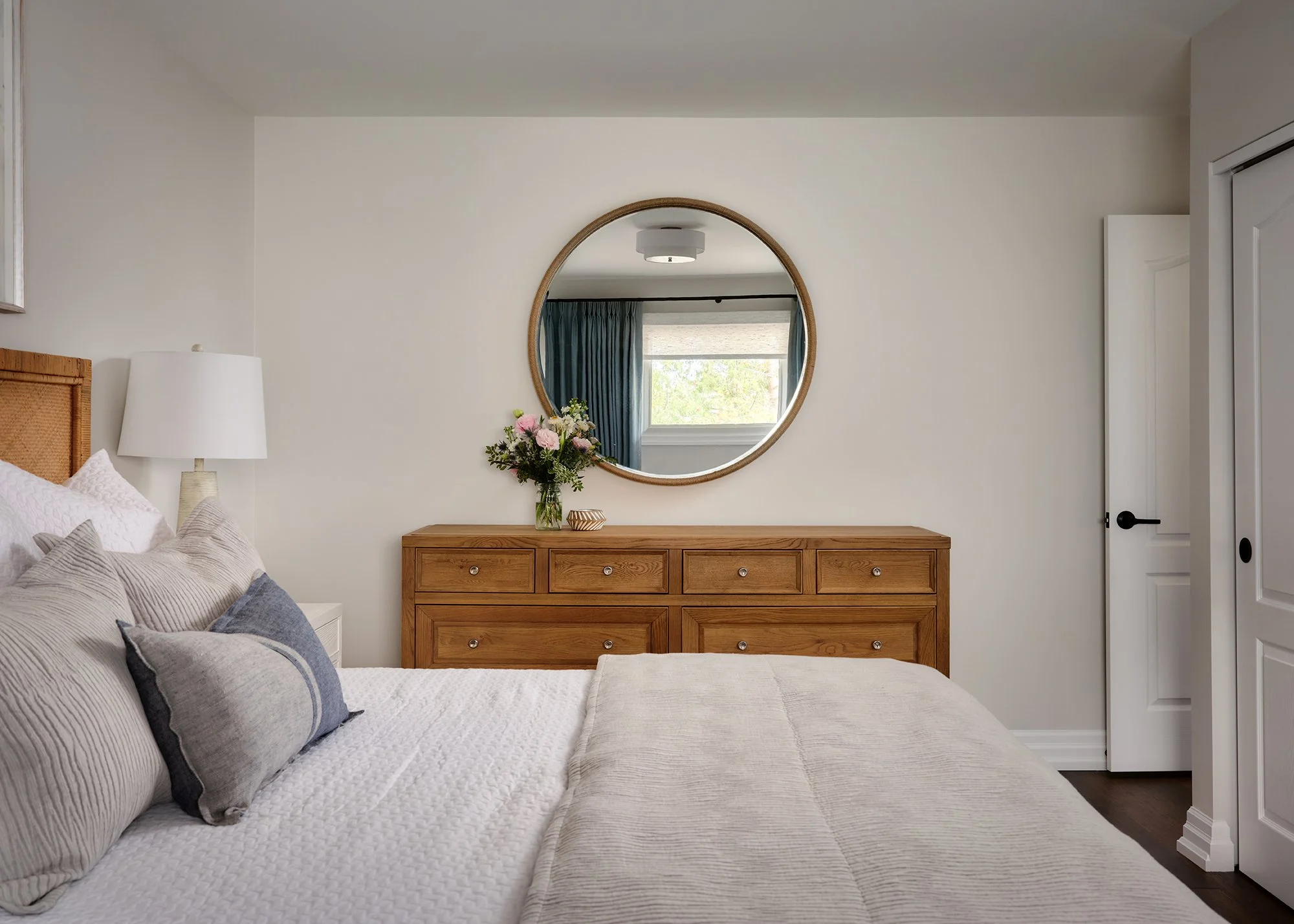 Principal bedroom renovation for an Ottawa family home featuring a large dresser and luxurious bedding.