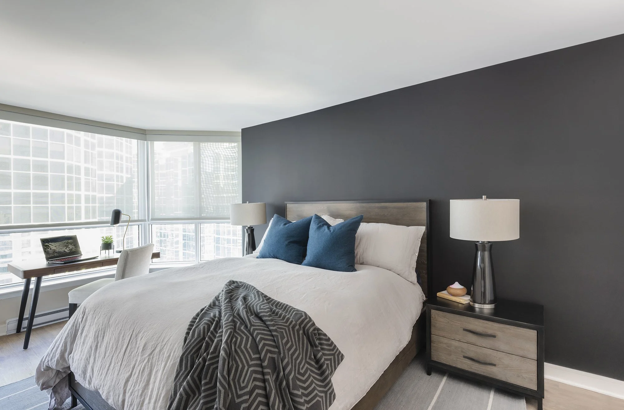 Guest bedroom makeover in Ottawa featuring a black accent wall and a solid wood storage drawer. 