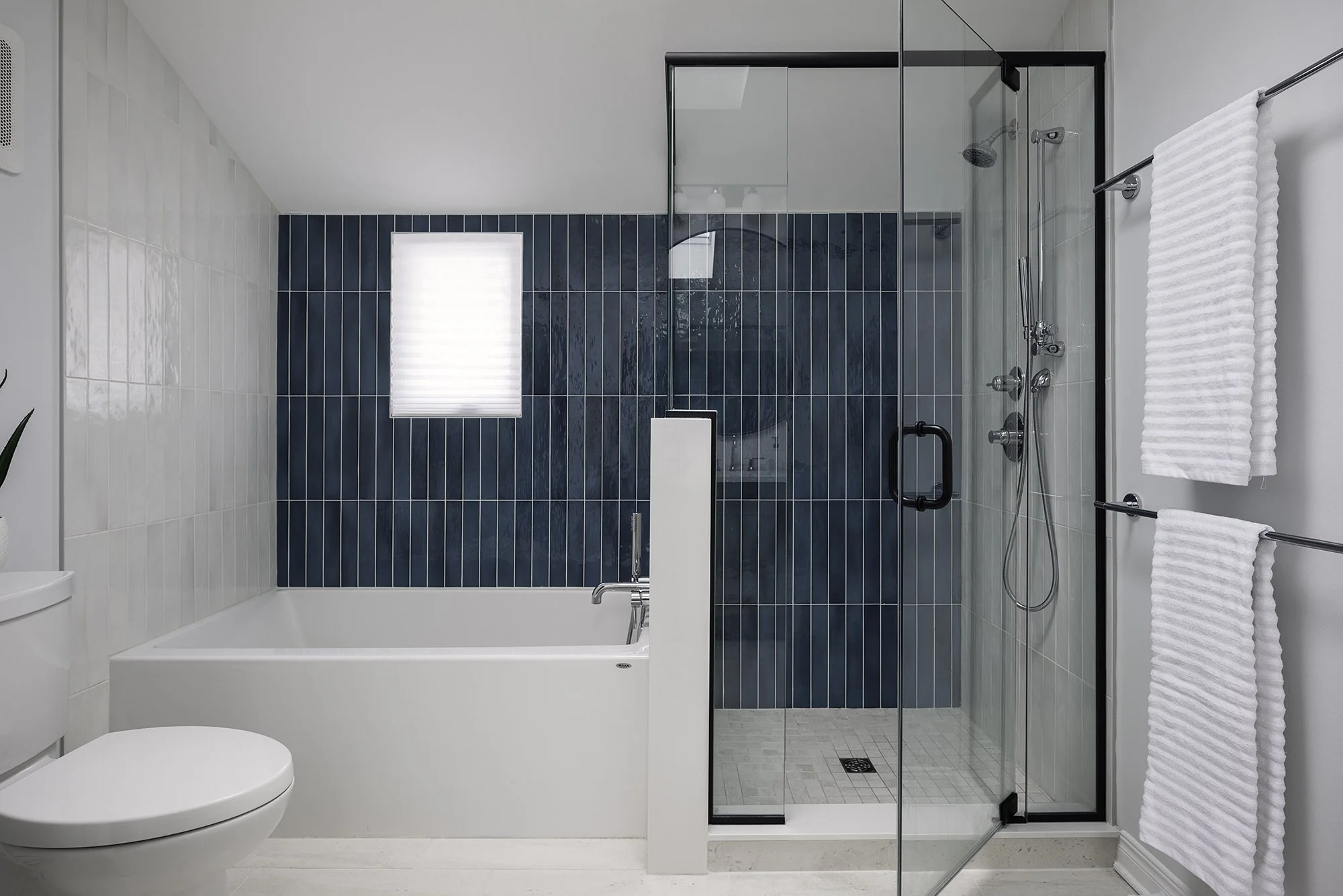 Ensuite bathroom renovation in Ottawa featuring a rich teal tile accent wall and a deep soaker tub. 