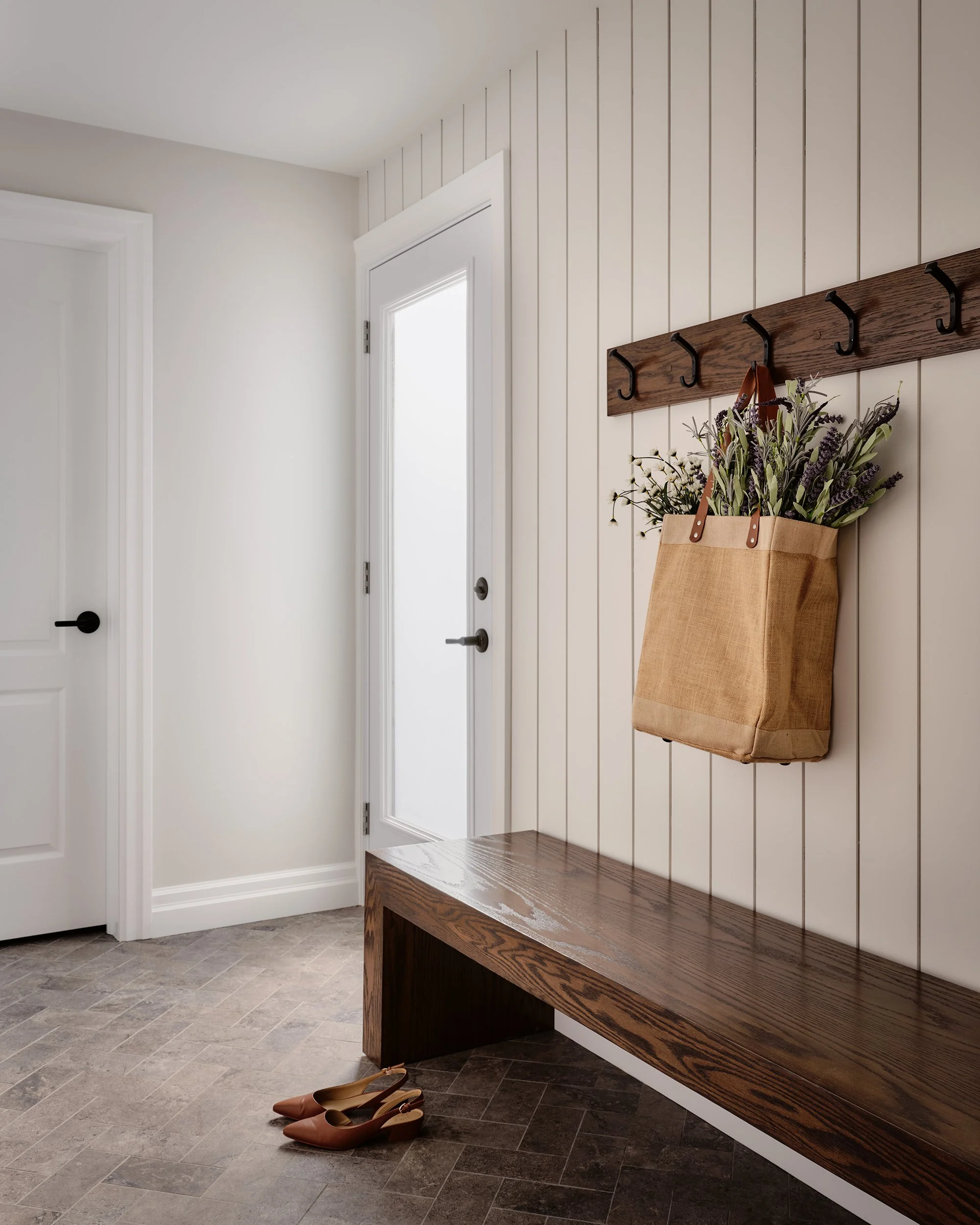 Whole home renovation for an Ottawa family home featuring a custom bench and hooks in their mudroom.