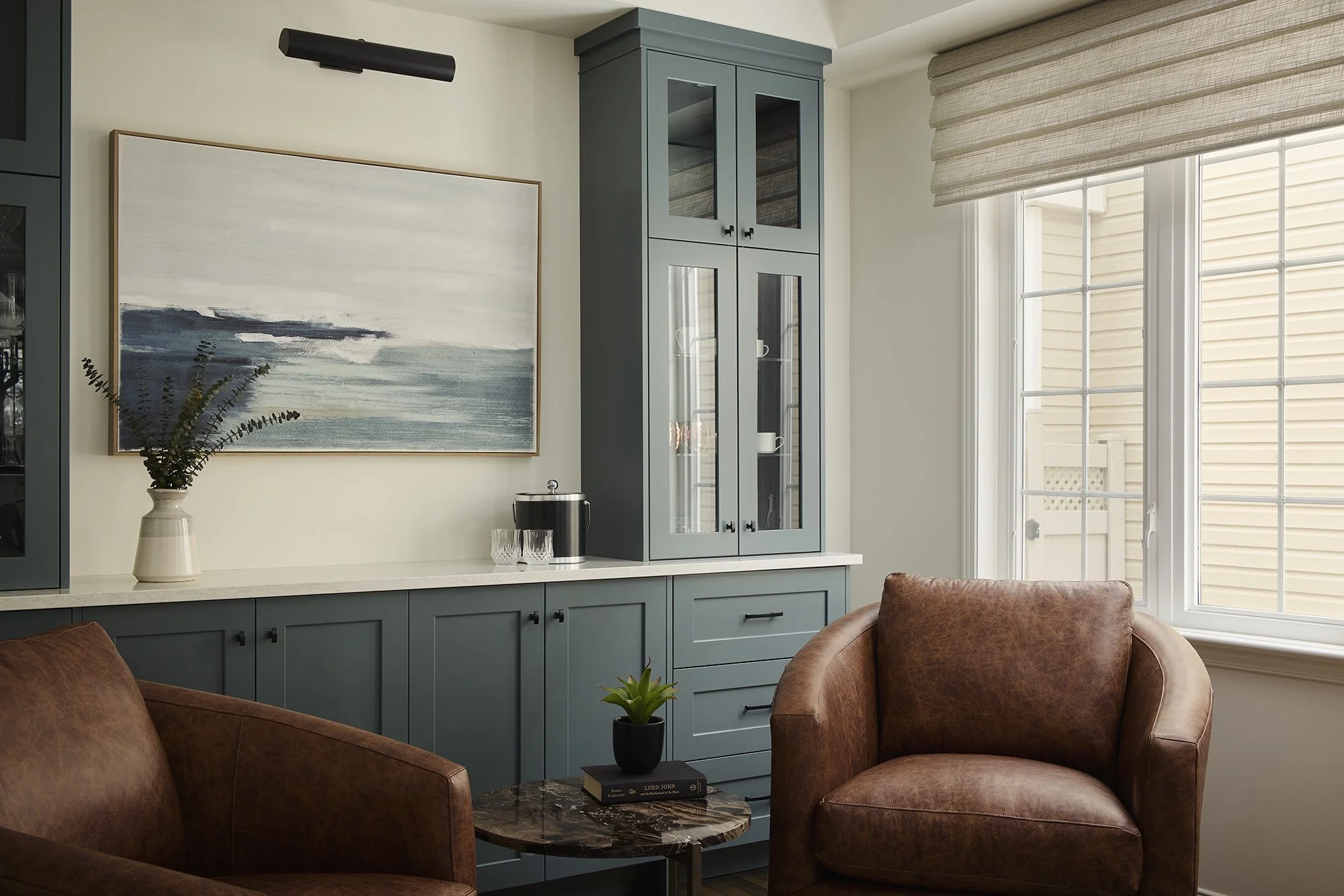 Dining room renovation in Ottawa featuring a bar made out of custom cabinetry in teal and a beautiful painting of the ocean. 