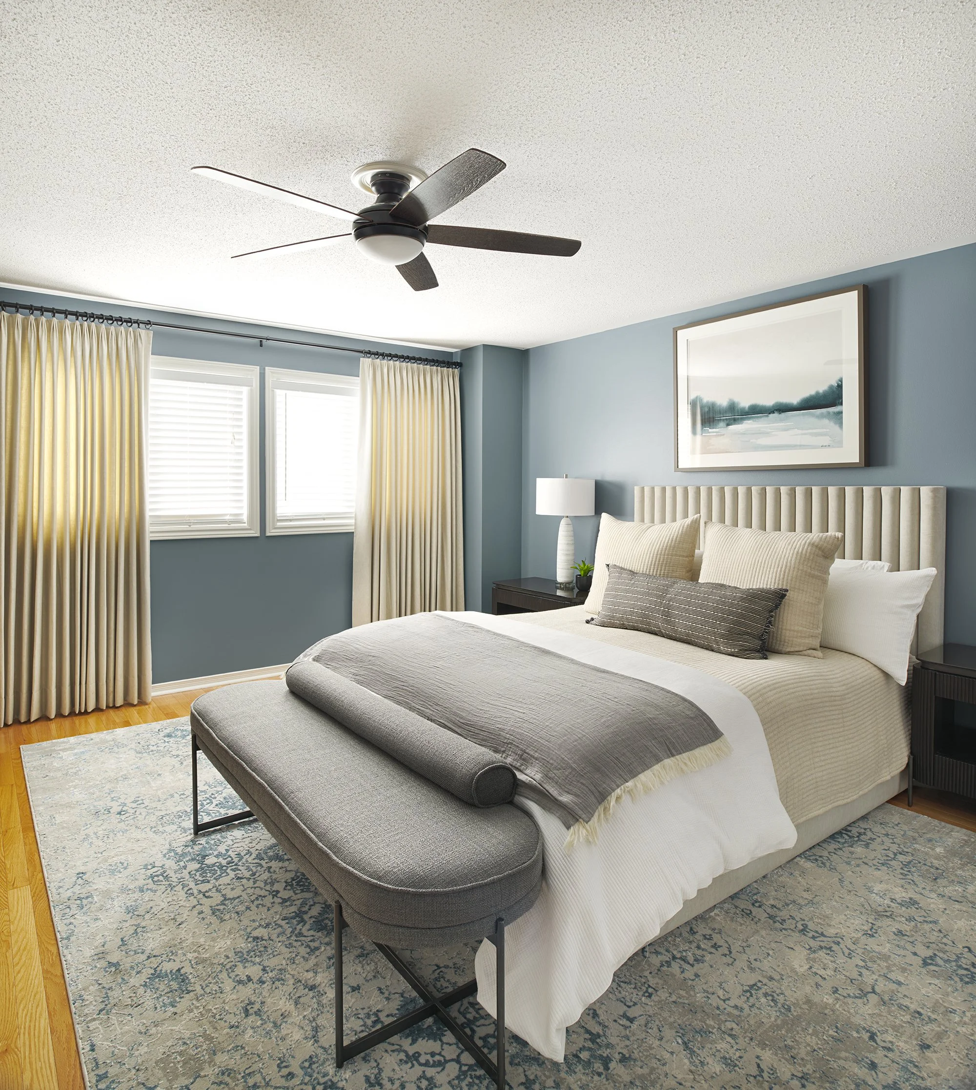 Principal bedroom design in Ottawa featuring an upholstered bed in a soft velvet and custom drapery. 