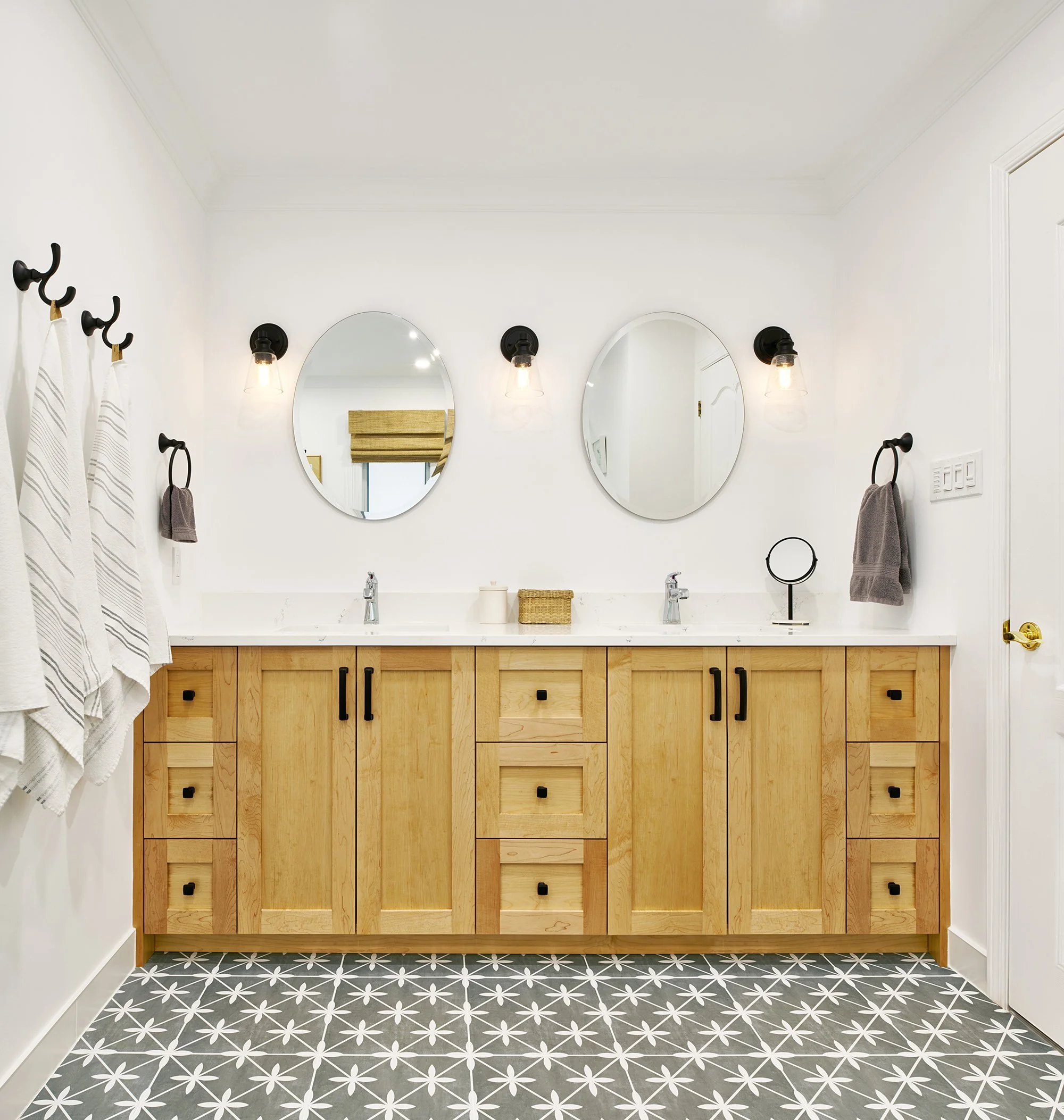 Ensuite bathroom design for an Ottawa family home featuring a natural maple vanity and patterned floor tile.