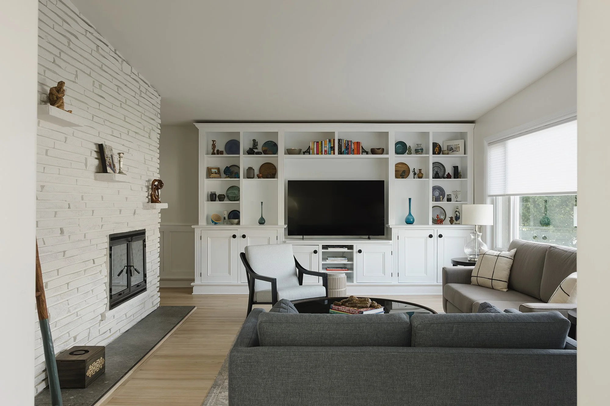 Ottawa interior design featuring a cozy family room with a painted brick fireplace. 