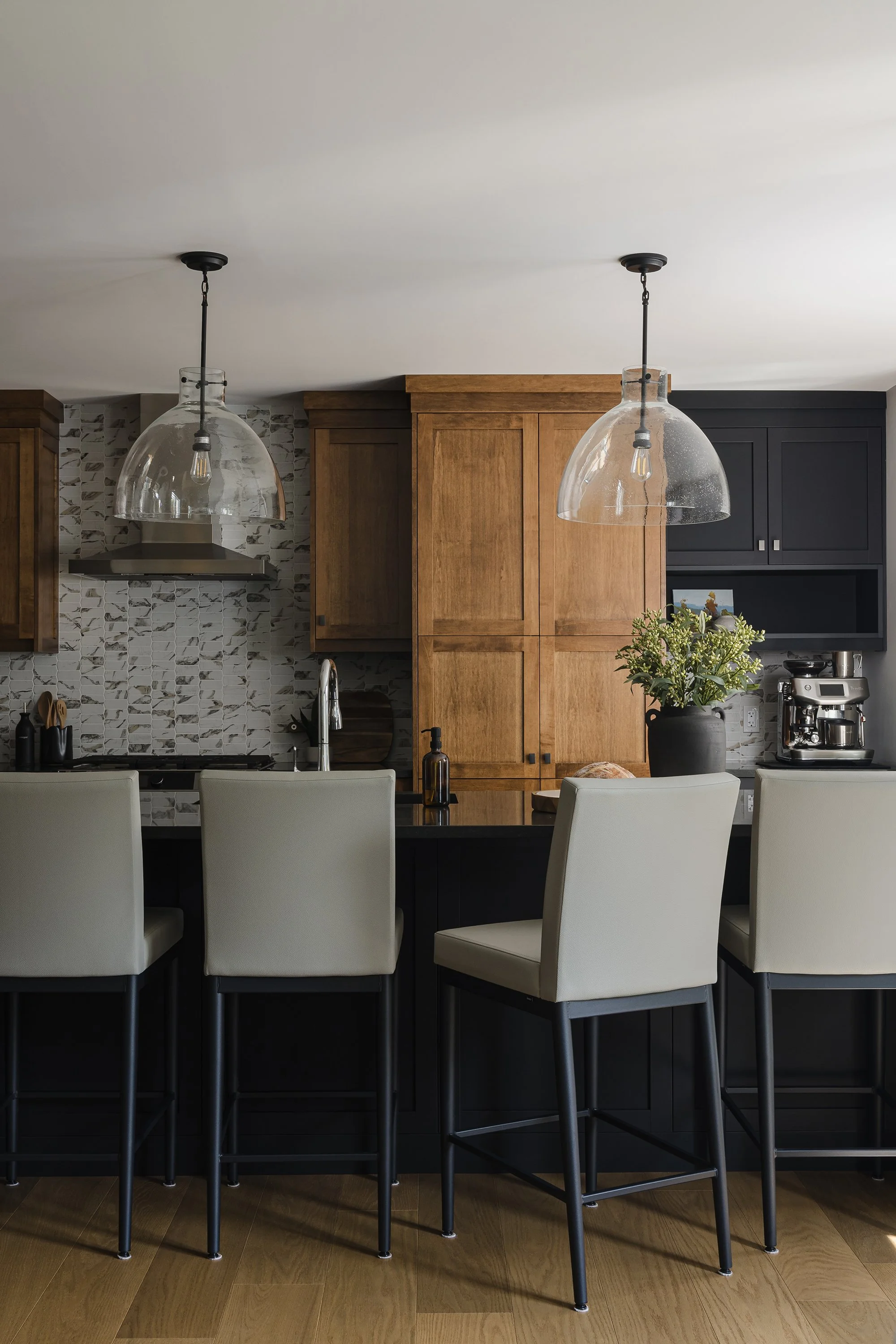 Custom kitchen renovation in Ottawa featuring warm maple cabinets and a black island. 