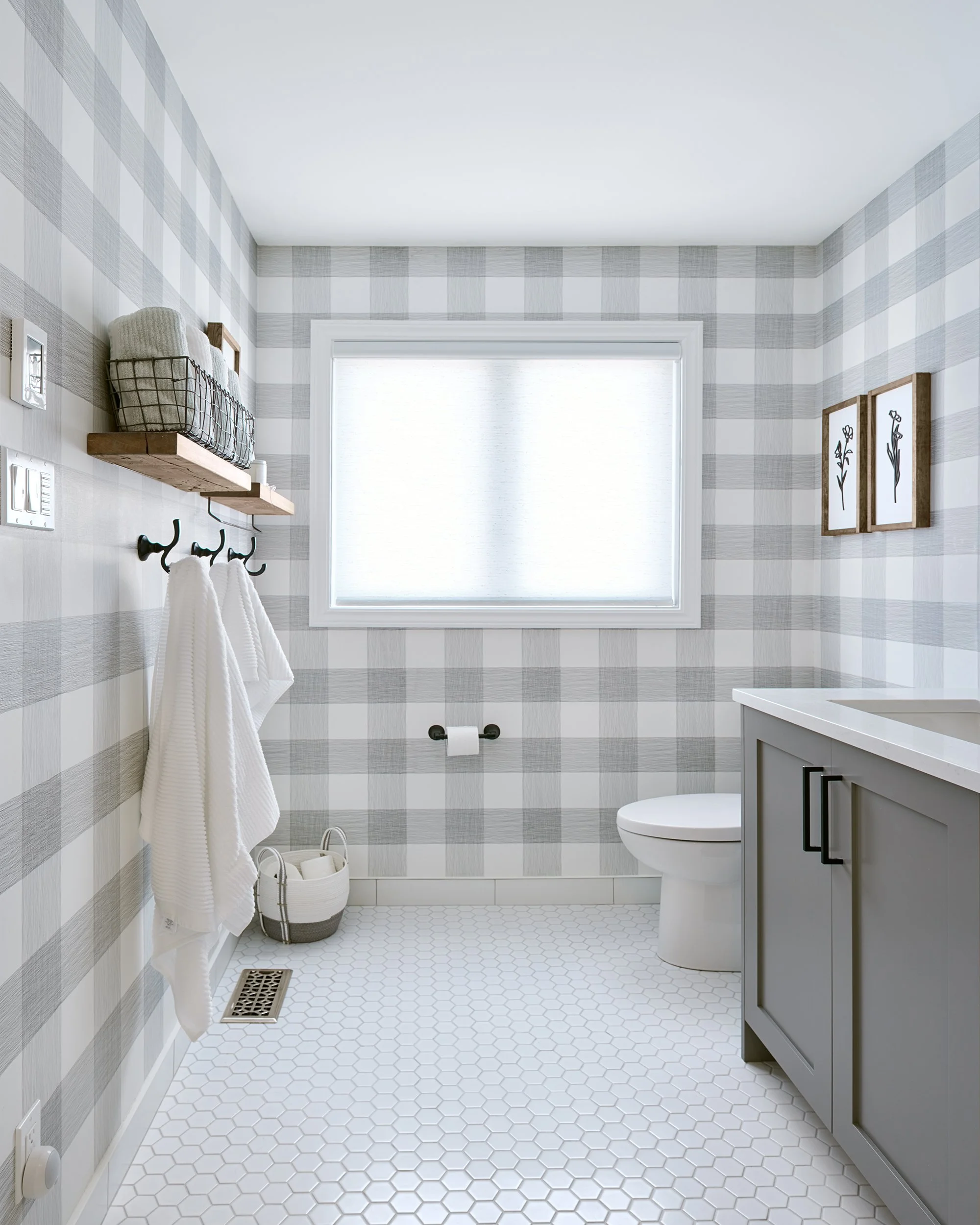 Ensuite bathroom renovation in Ottawa featuring custom grey vanity and dramatic plaid wallpaper. 