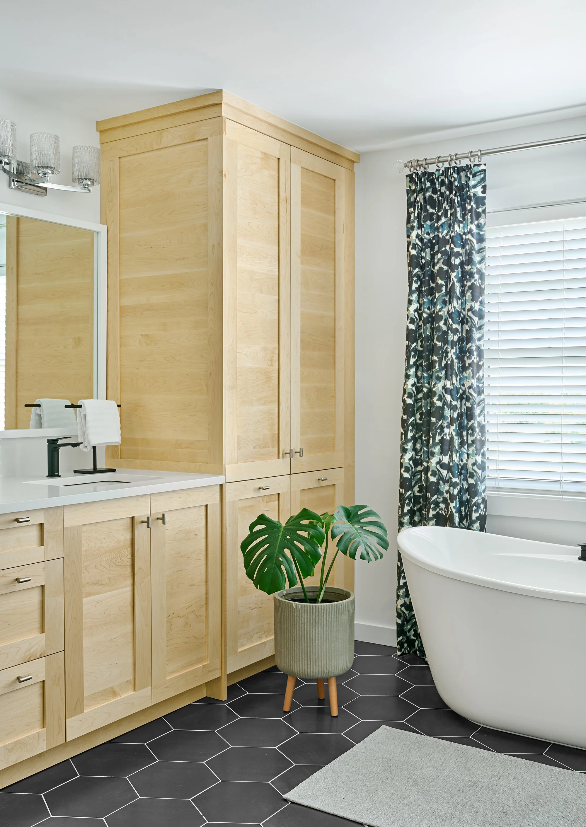 Custom ensuite renovation in Ottawa featuring natural maple cabinets and a hexagon tile flooring. 