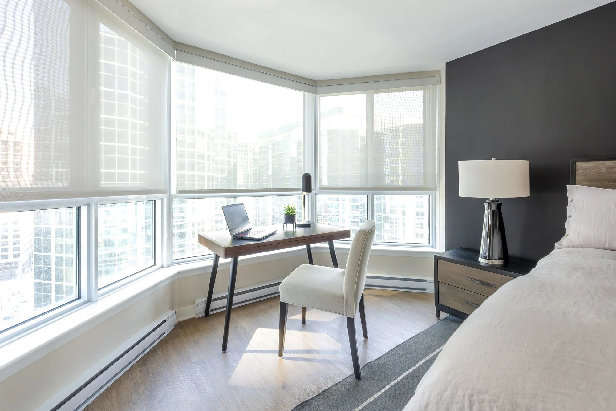 Ensuite bedroom makeover in Ottawa featuring  a black accent wall and a desk with a beautiful view. 