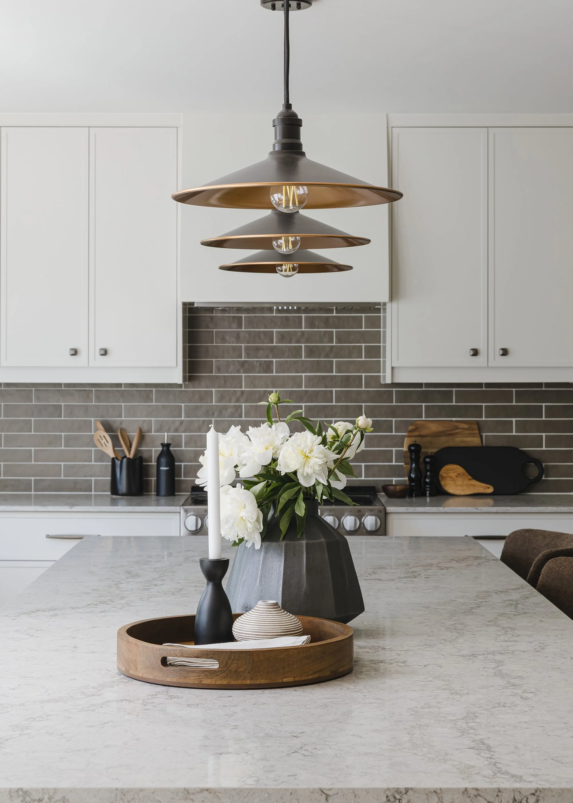 Custom kitchen design for an Ottawa family home featuring light coloured skinny shaker cabinets and a neutral quartz countertop. 