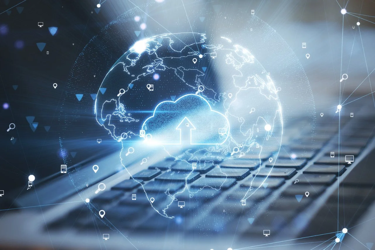 Digital global cloud computing concept over a keyboard, featuring a globe with connecting lines and cloud icon with an upward arrow.