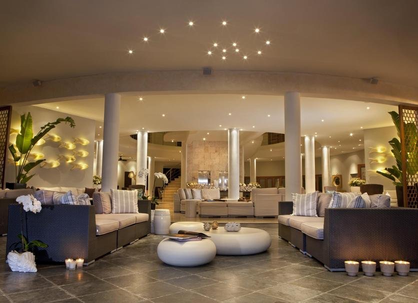 Elegant hotel lobby with modern furniture, soft lighting, and decorative plants.