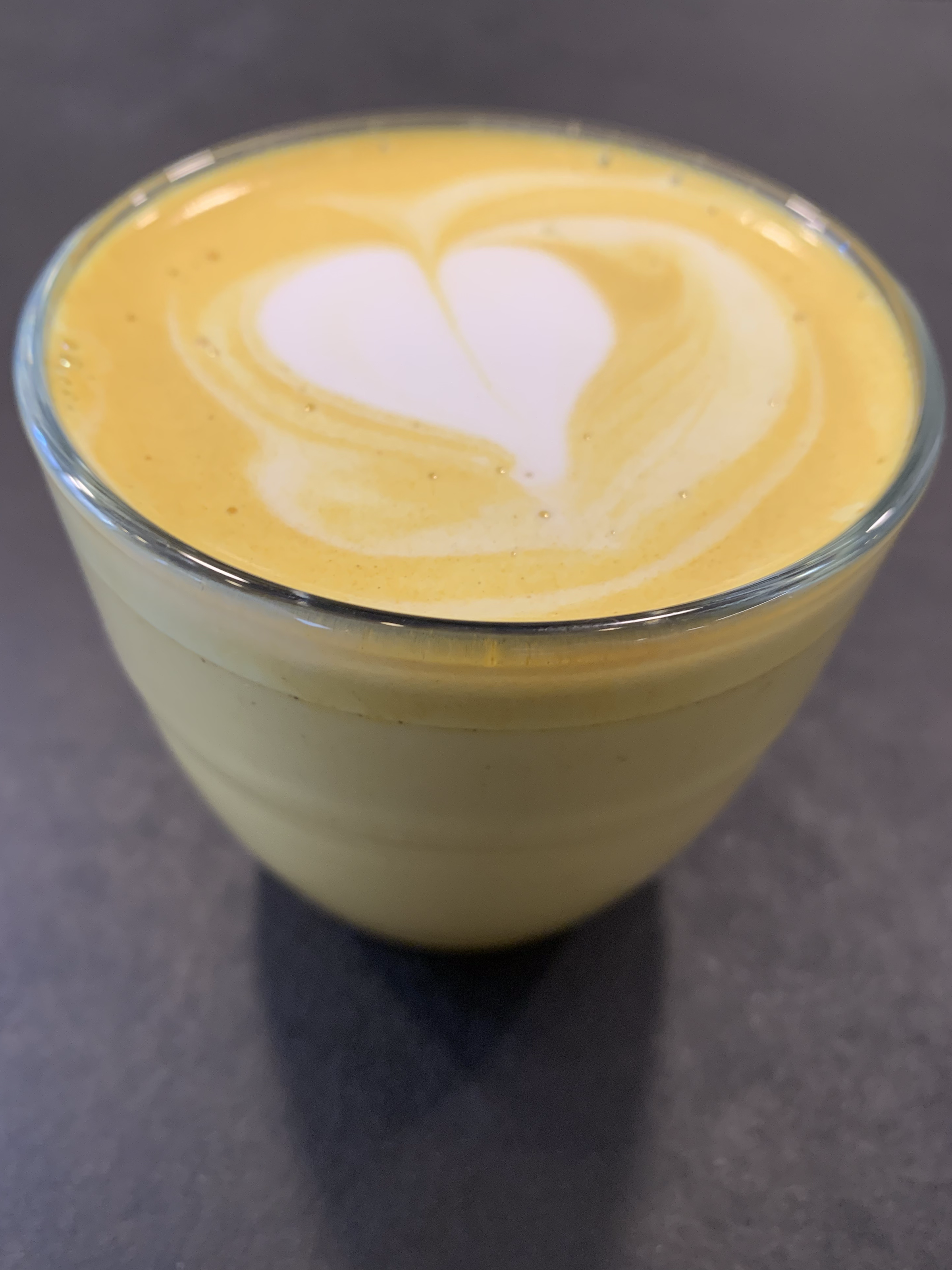 Leche dorada con latte art en corazón en Explora Family Café Madrid