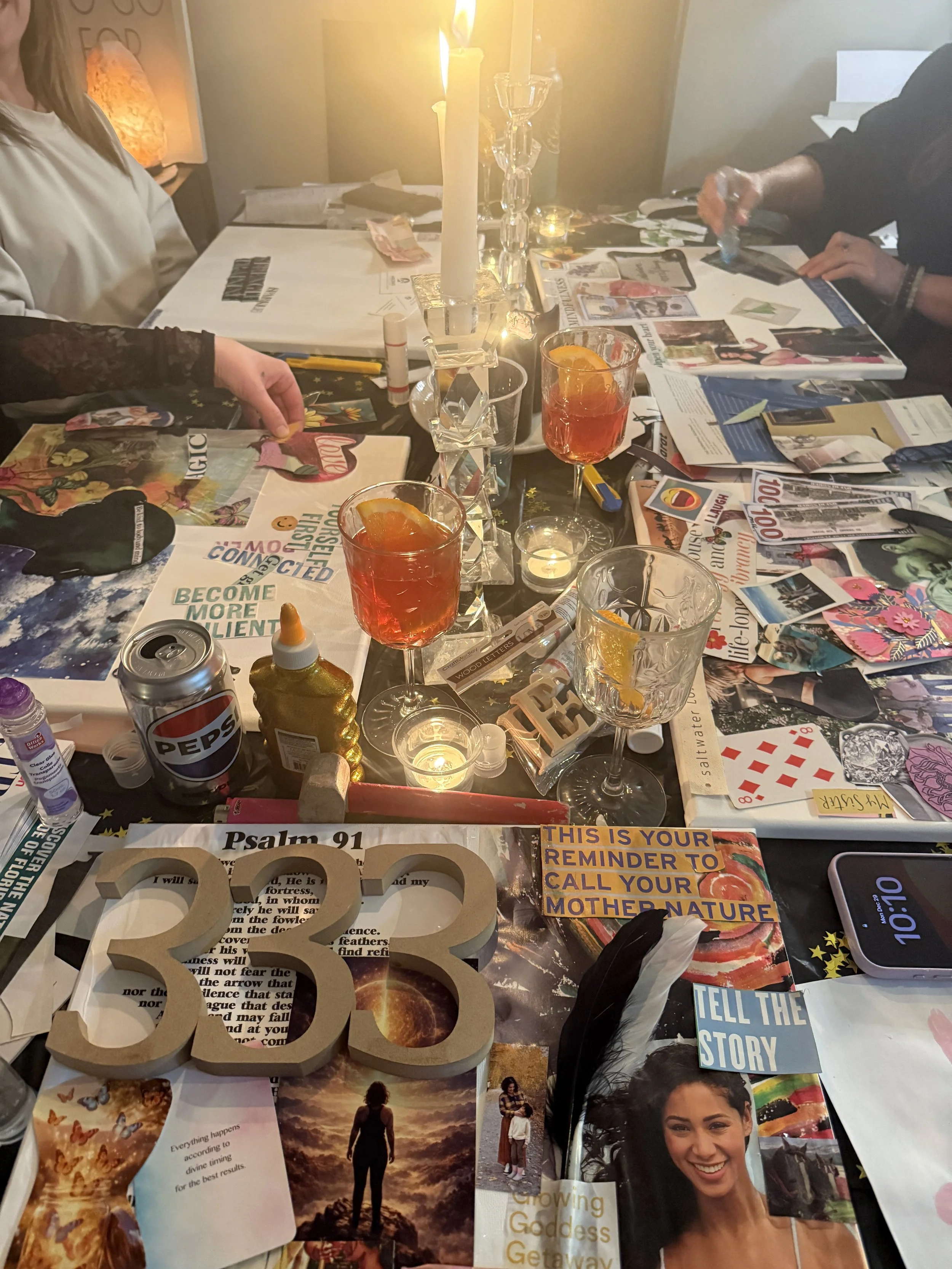 A decorated table with candles, drinks, magazines, and various decorative items, set for a gathering or celebration.