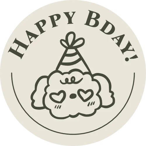 A circular graphic with the text "Happy BDay!" at the top. In the center, there is a cartoon drawing of a cute dog wearing a party hat, with heart-shaped glasses, a small nose, and a smiling mouth.