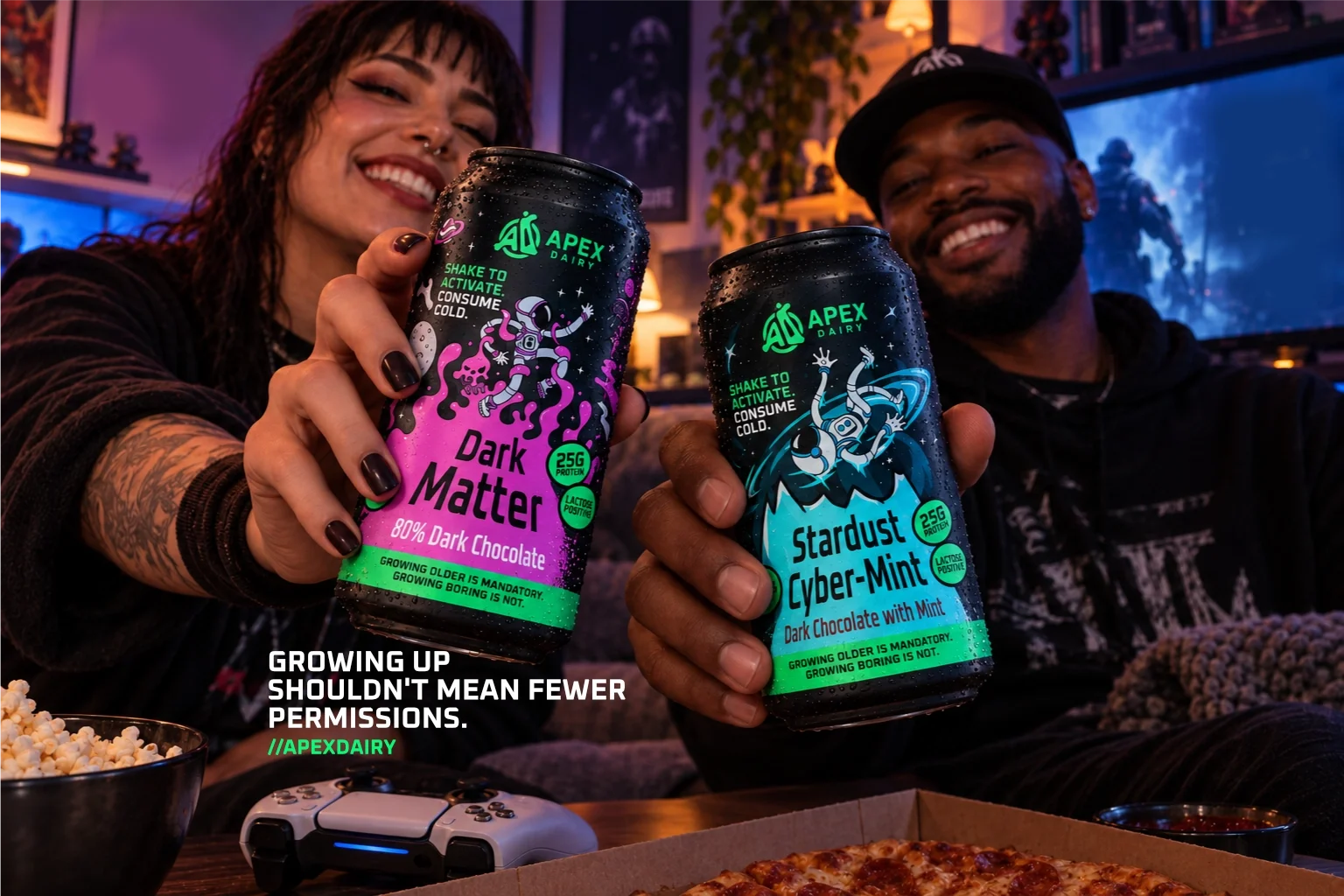 Two people smiling and toasting with cans of dark chocolate and stardust cyber-mint dark chocolate drinks in a cozy room with gaming and gaming controllers on the table.