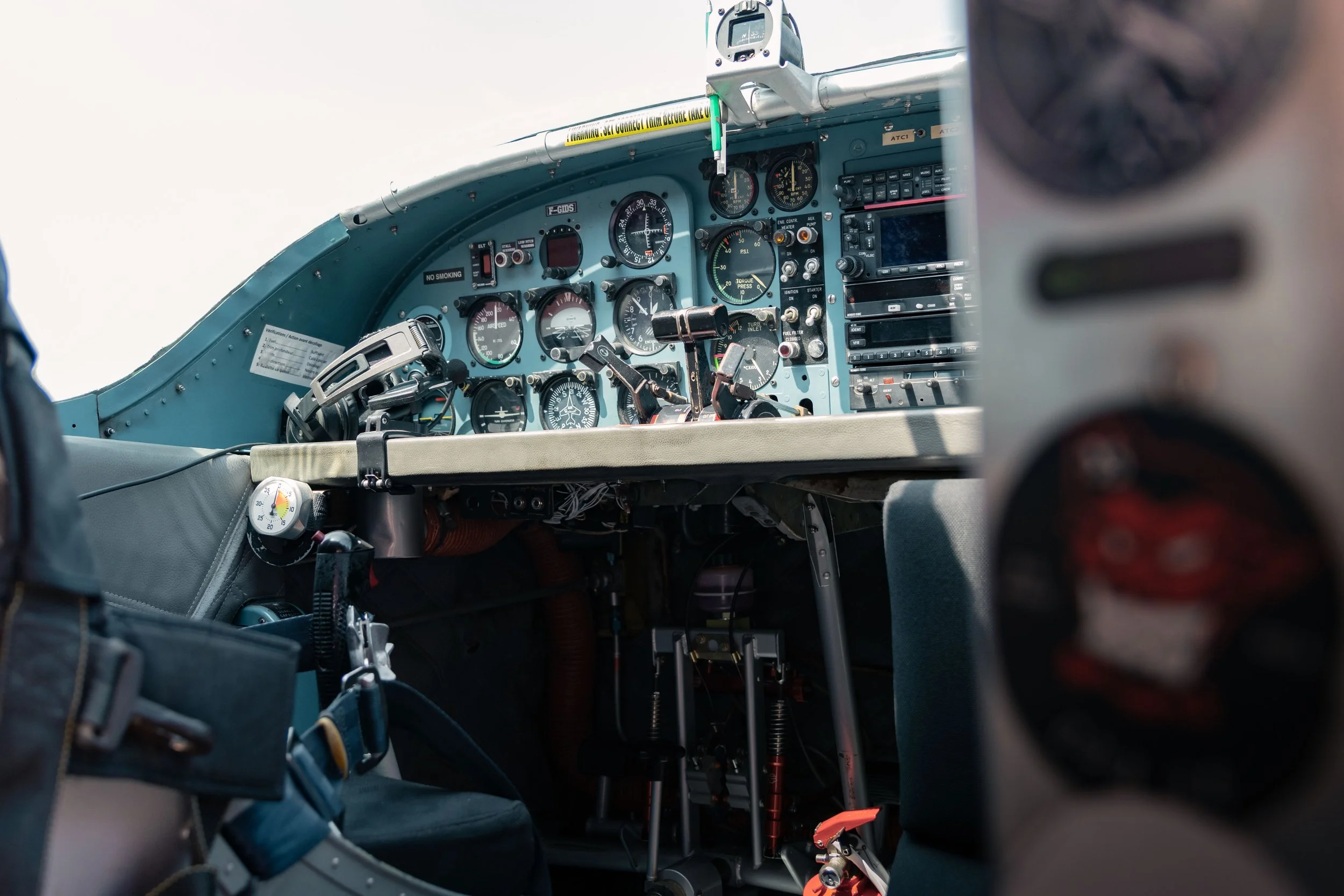 Intérieur du cockpit d'un avion pilatus avec divers instruments, manettes et cadrans.