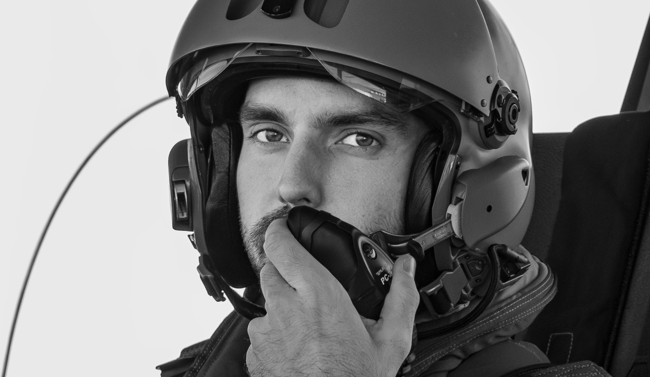Pilote de chasse Français portant un casque de pilote, en train de parler dans un casque de communication.