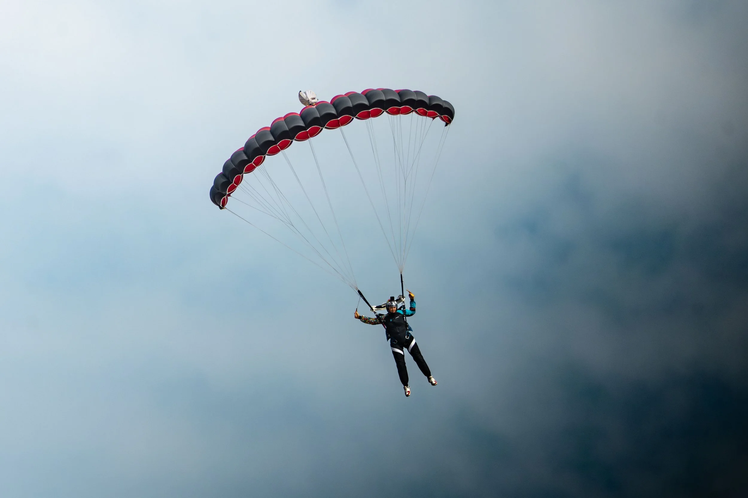 Personne en parachute en plein vol dans un ciel nuageux
