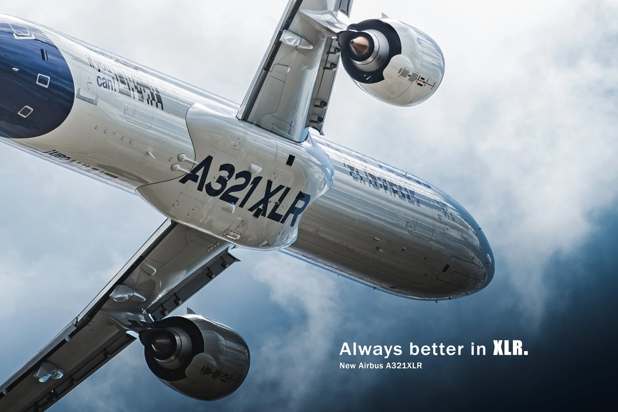 Photo d'un avion Airbus A321XLR en vol, vu de dessous contre un ciel nuageux. Textes sur l'image : "Always better in XLR. New Airbus A321XLR".