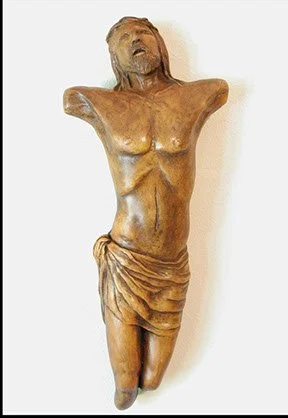 Wooden sculpture of a woman with her head tilted back and eyes closed, wearing a draped skirt.