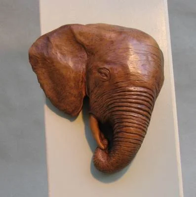 Elephant head sculpture mounted on a wall.