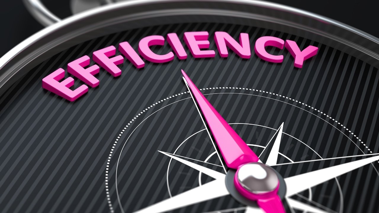 A close-up image of a speedometer with the needle pointing near the word 'Efficiency' written in pink on the dial.