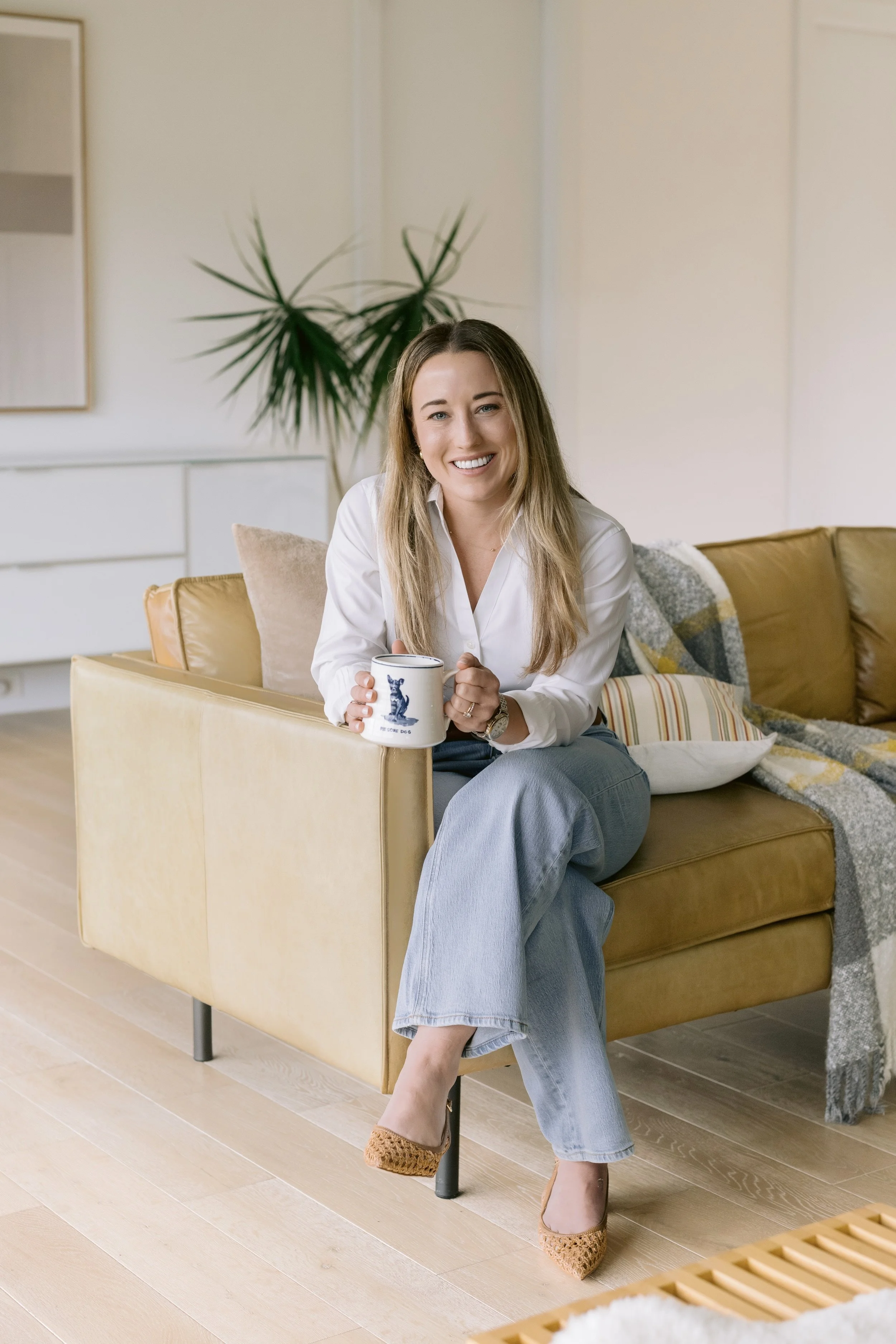 Therapist holding a mug while sitting on a couch