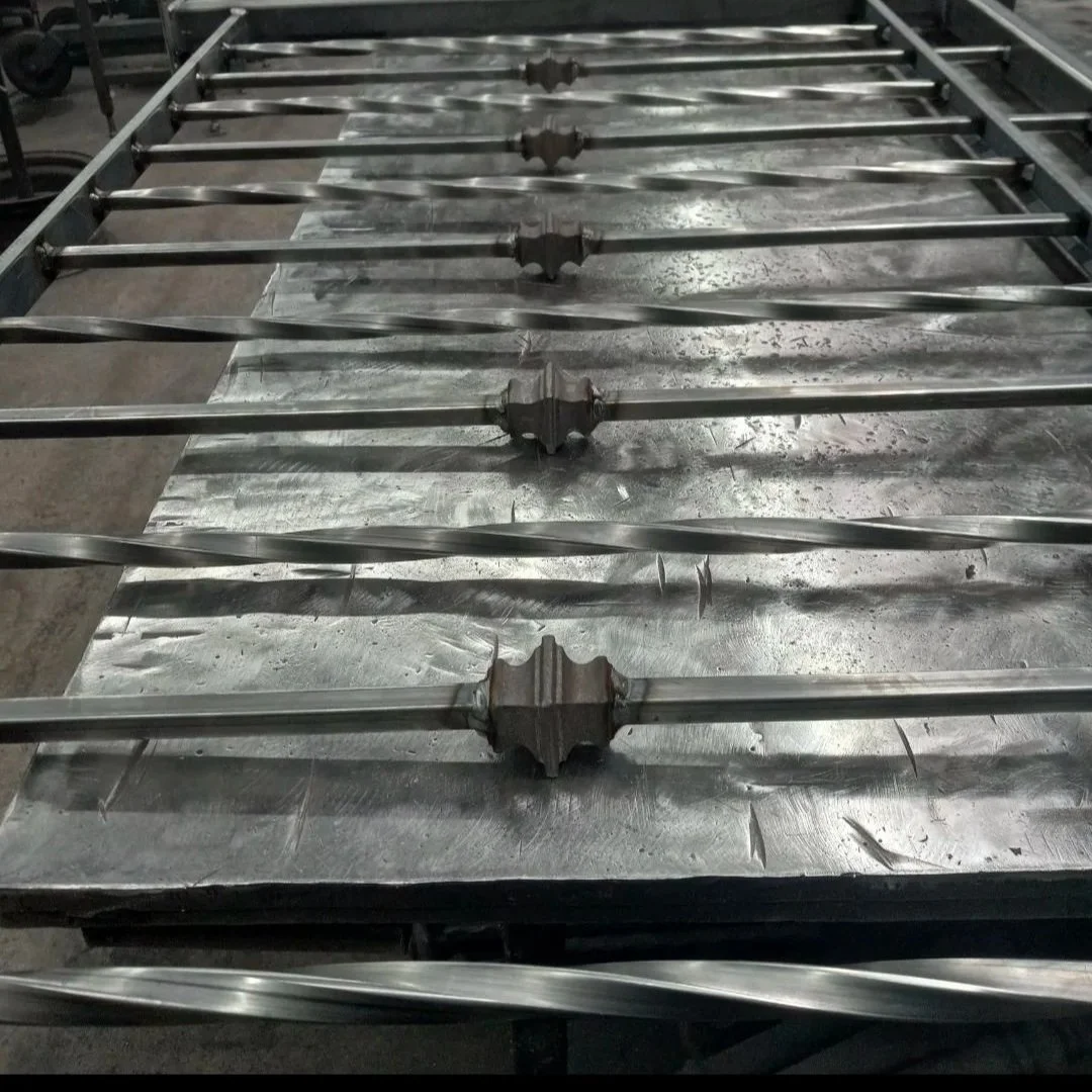 Metal worktable with evenly spaced metal rods secured by large metal brackets, in a workshop or manufacturing environment.