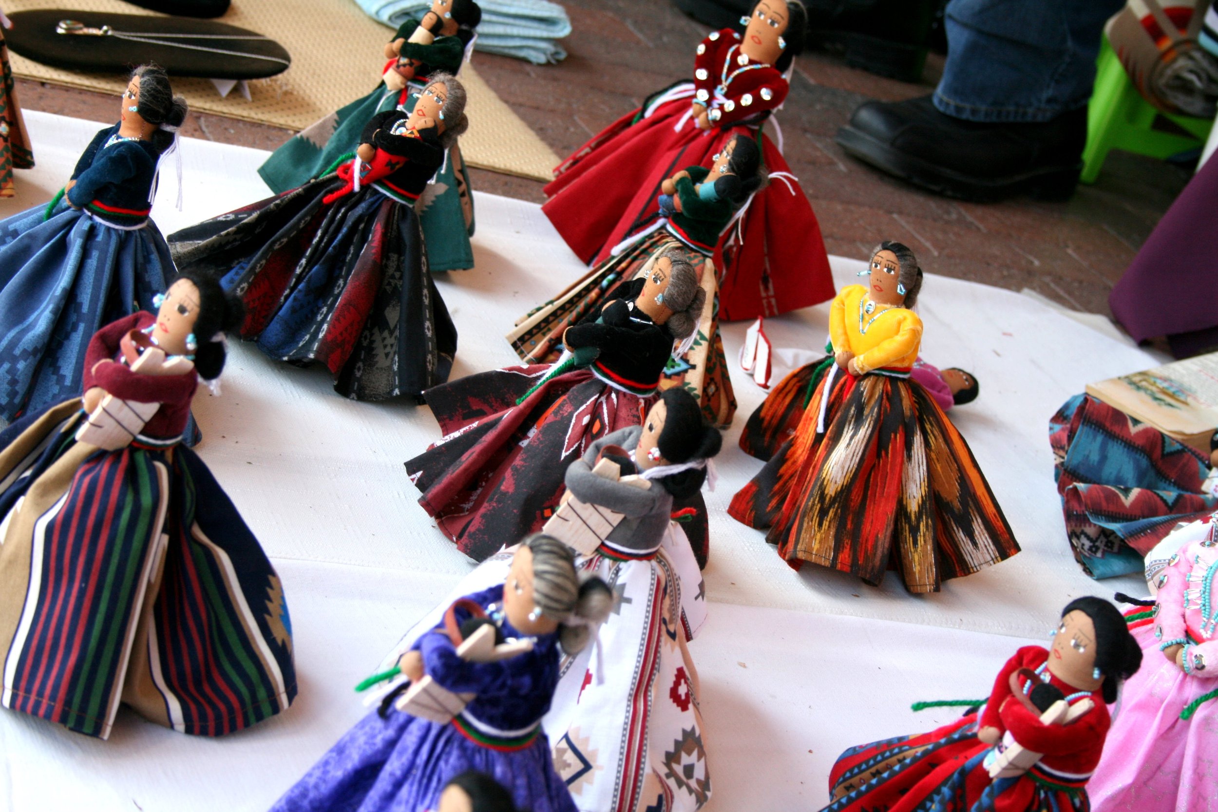 Colorful handmade dolls dressed in traditional Mexican clothing displayed on a table.