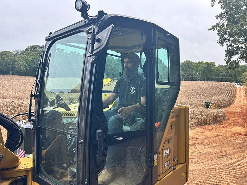 John Michael Johnson, owner of Circle J Earthworks, in the cab of his excavator
