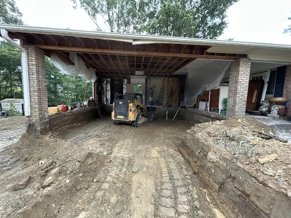 Skid steer removing material from a carport during demolition