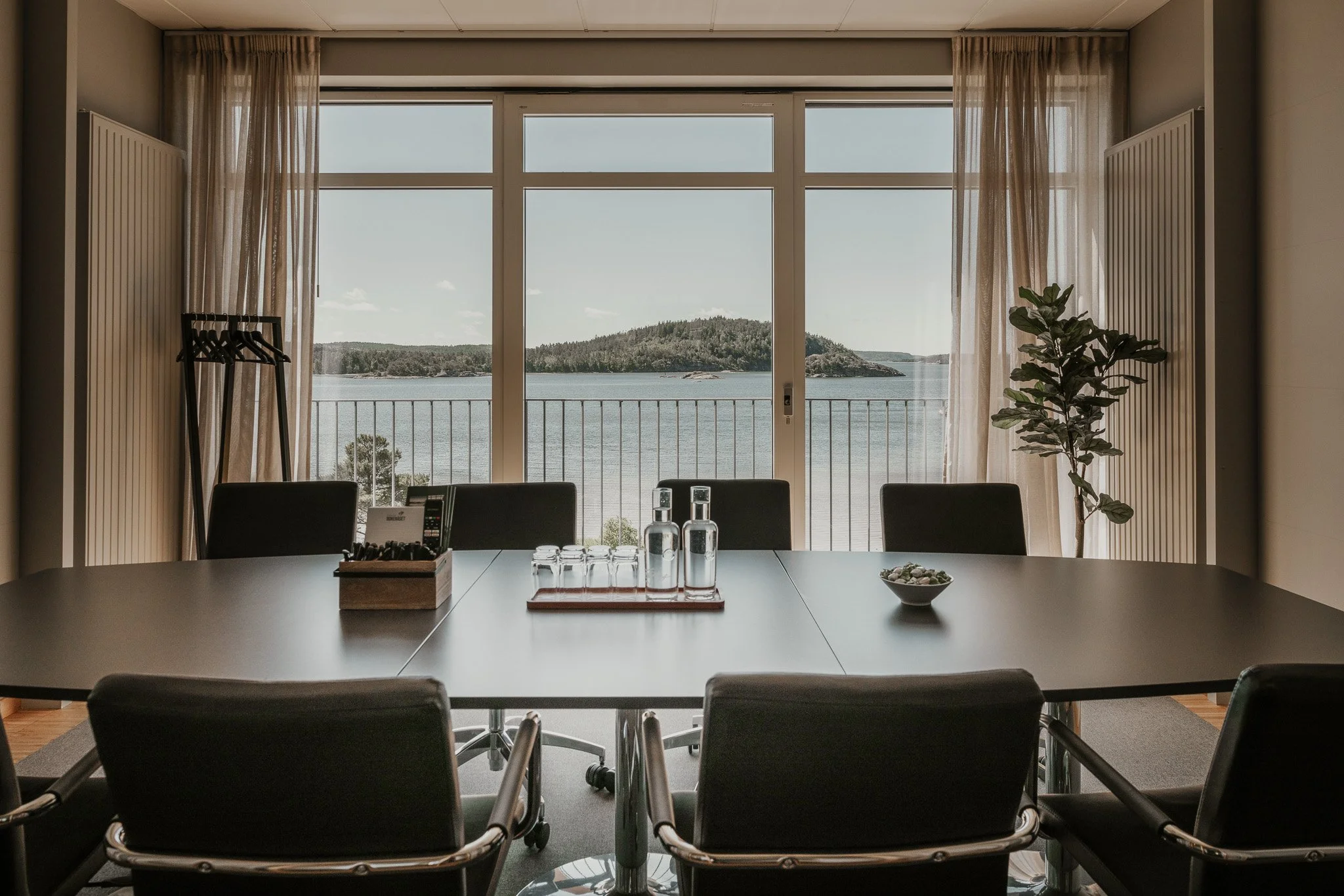 Salle de conférence avec grande fenêtre donnant sur le lac et les îles.