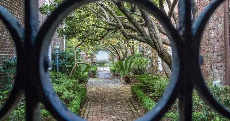 Looking through a gate into a historic Charleston courtyard