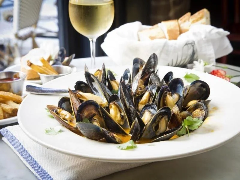a bowl of mussels on a table during a Charleston upper king street food tour