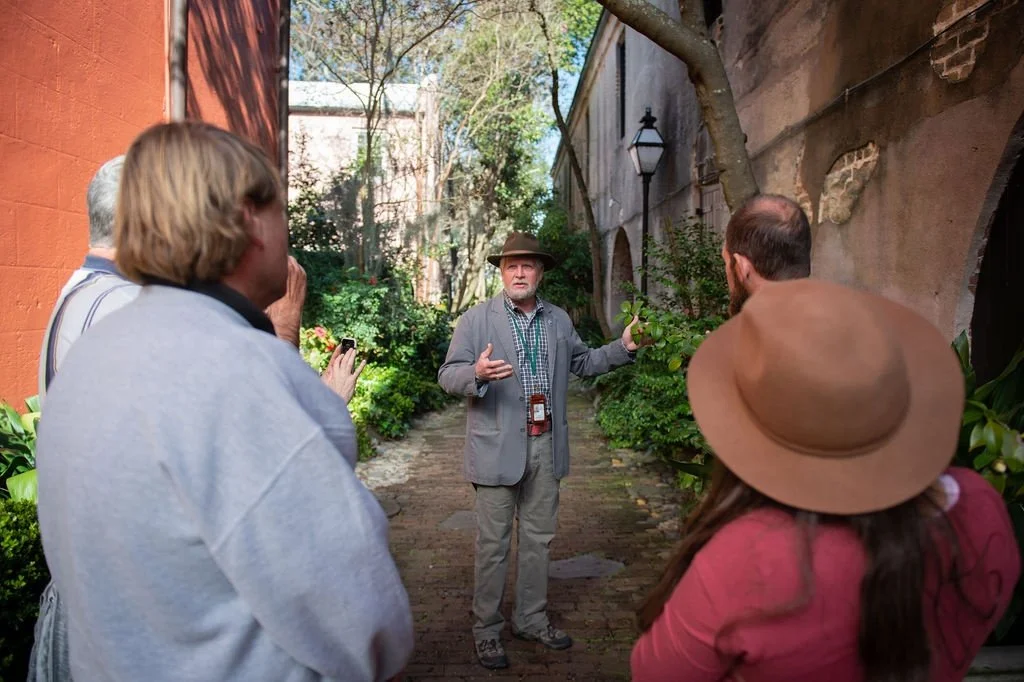 Tour guide recounting history to tour group in Charleston hidden alley