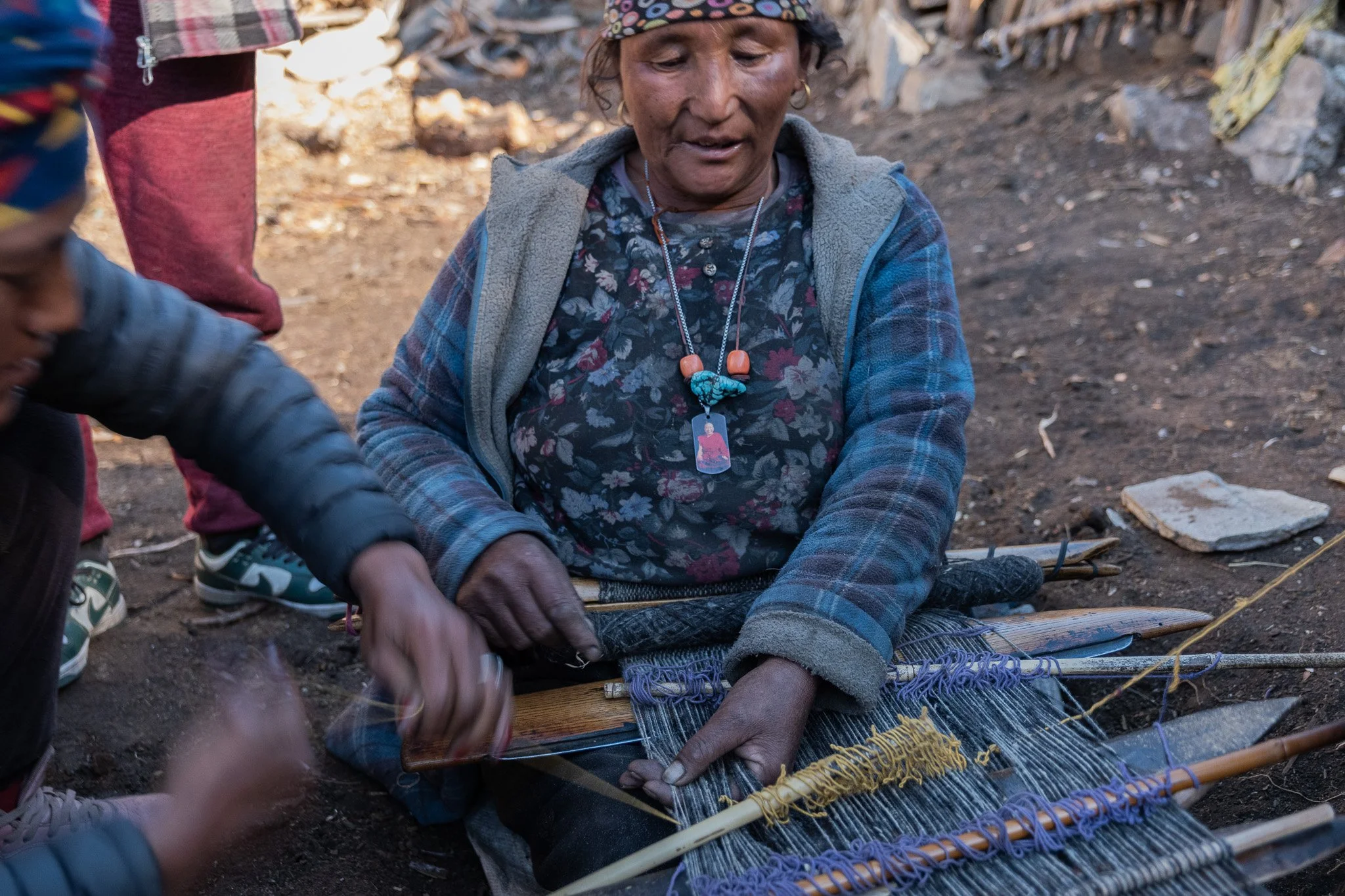 A woman weaving outside her home in Nepal's Nar Phu region