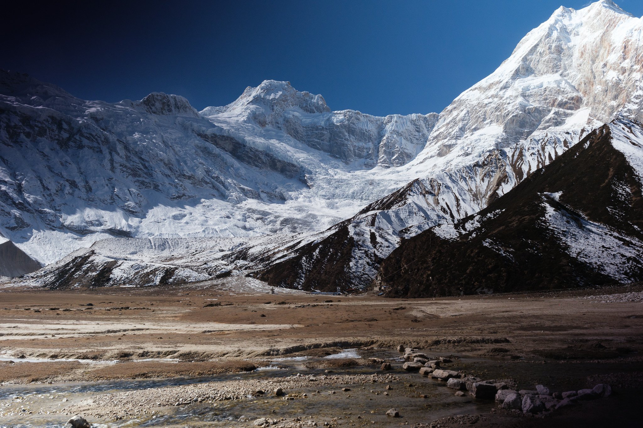 Pungyen monastery in the distance on a vast alpine grassland at the foot of Manaslu in Nepal