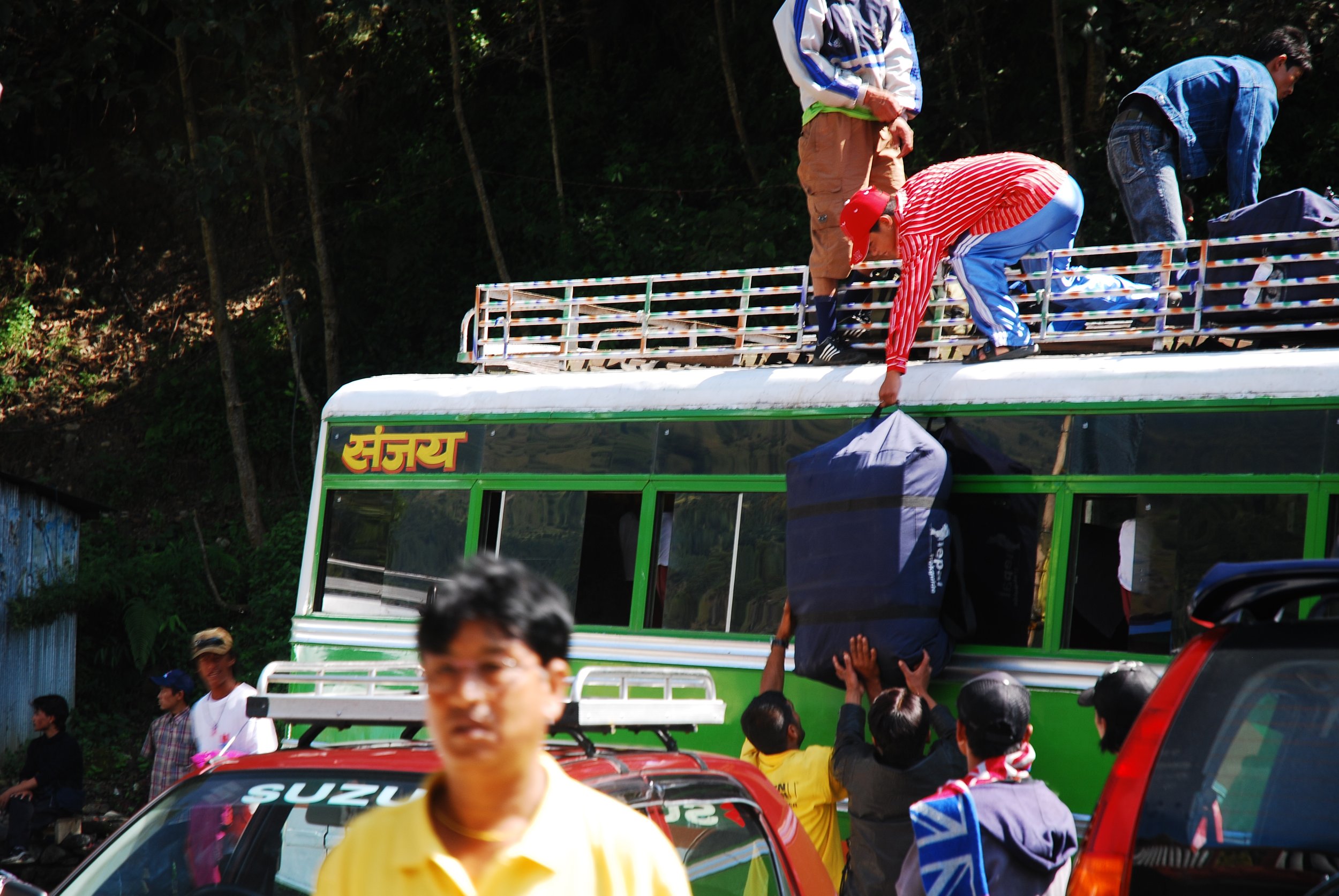 Porters loading luggage on a public bus in Nepal